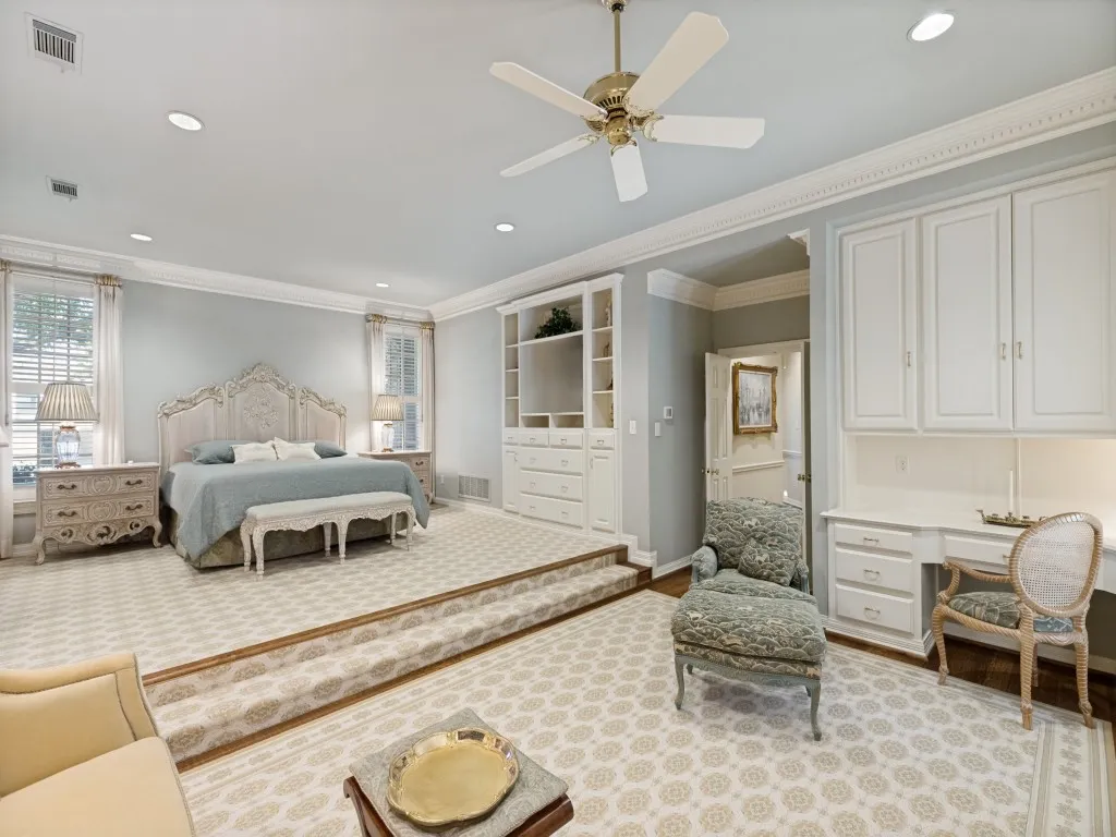 Raised sleeping area with recessed lighting, crown molding, built-in cabinetry, ceiling fan, and dedicated desk space