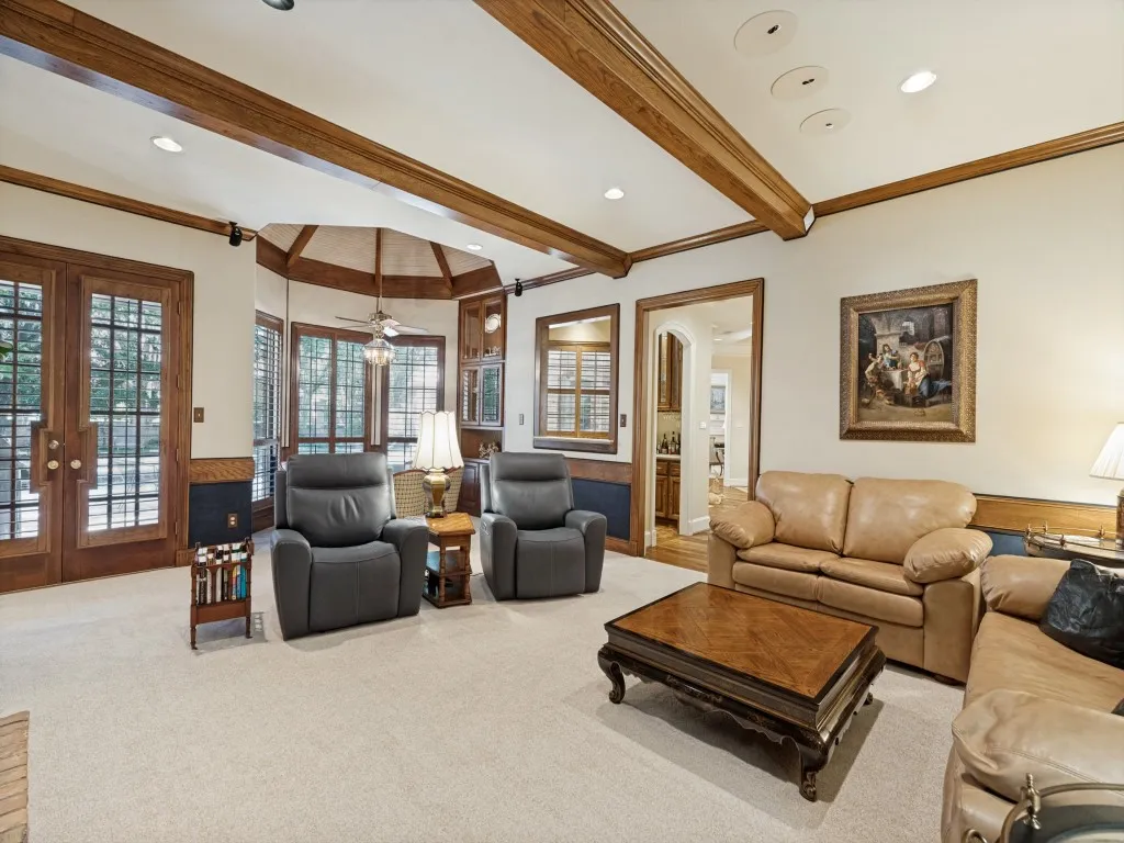 Recessed lighting, exposed wood ceiling beams, French doors, and a bay window provide abundant natural light