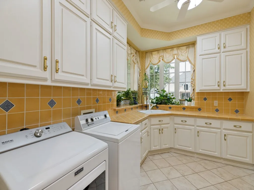 White cabinetry with gold-tone hardware, a tiled countertop, and a tiled backsplash with diamond accents