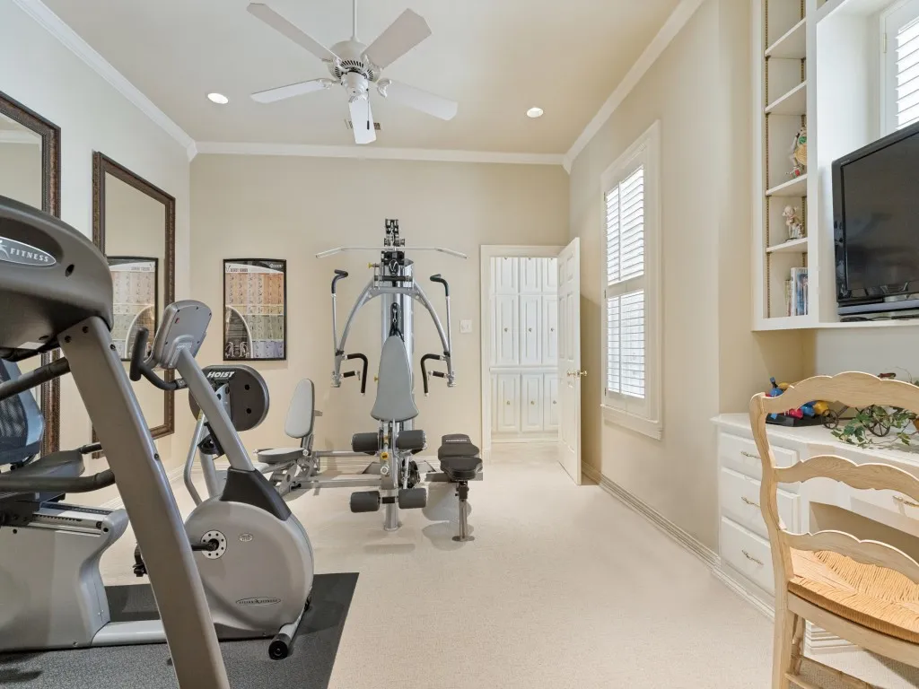 Recessed lighting, crown molding, ceiling fan, white plantation shutters, built-in shelving