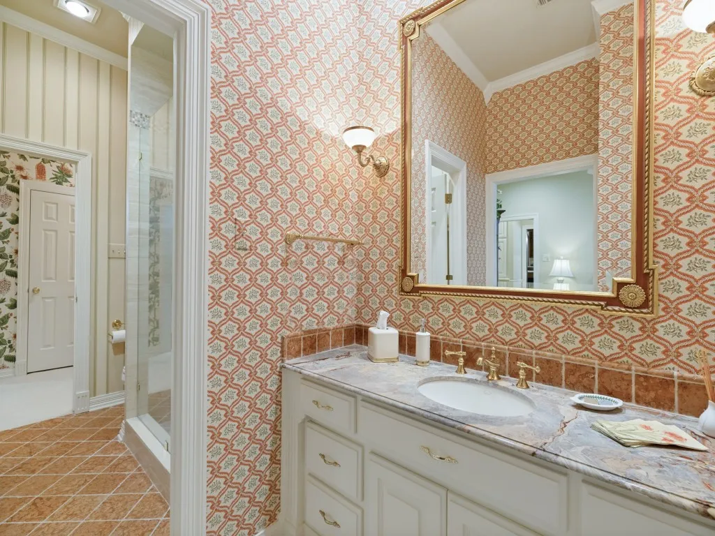 Vanity with an integrated sink, polished brass fixtures, and a framed mirror