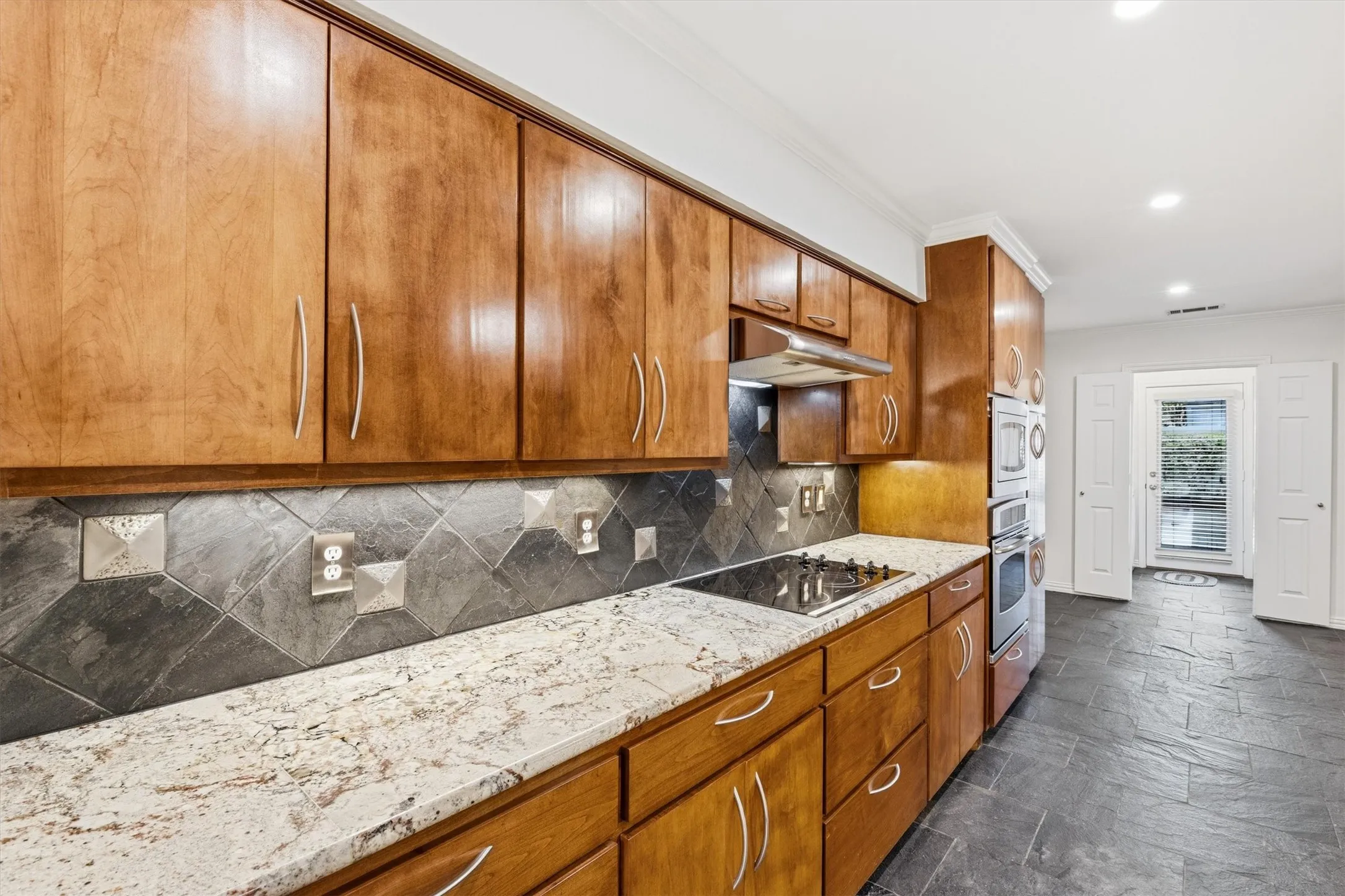 Updated kitchen with custom cabinets, granite counter, stainless appliances with smooth cooktop and under counter lighting...