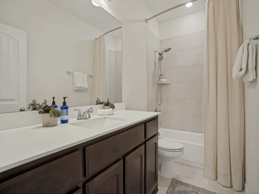 Built-in vanity with a single basin sink, white countertop, and dark wood-finish cabinetry