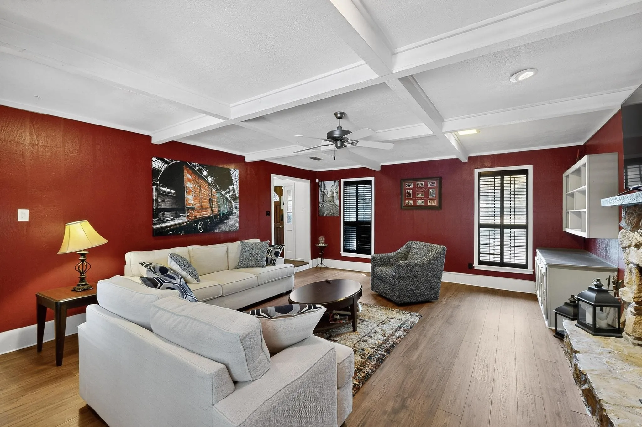 Living area with wood finished floors, beam ceiling, ceiling fan, and coffered ceiling