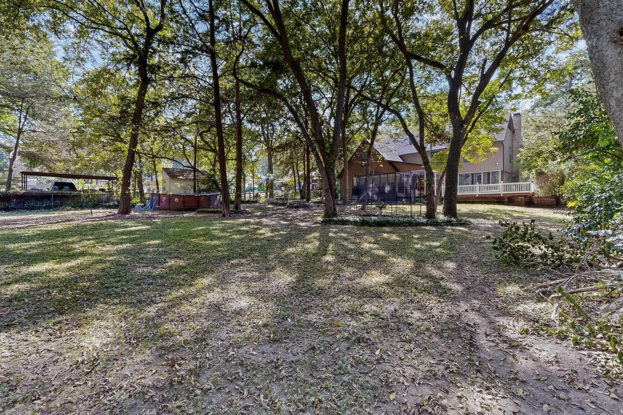 View of yard with a wooden deck and view of scattered trees