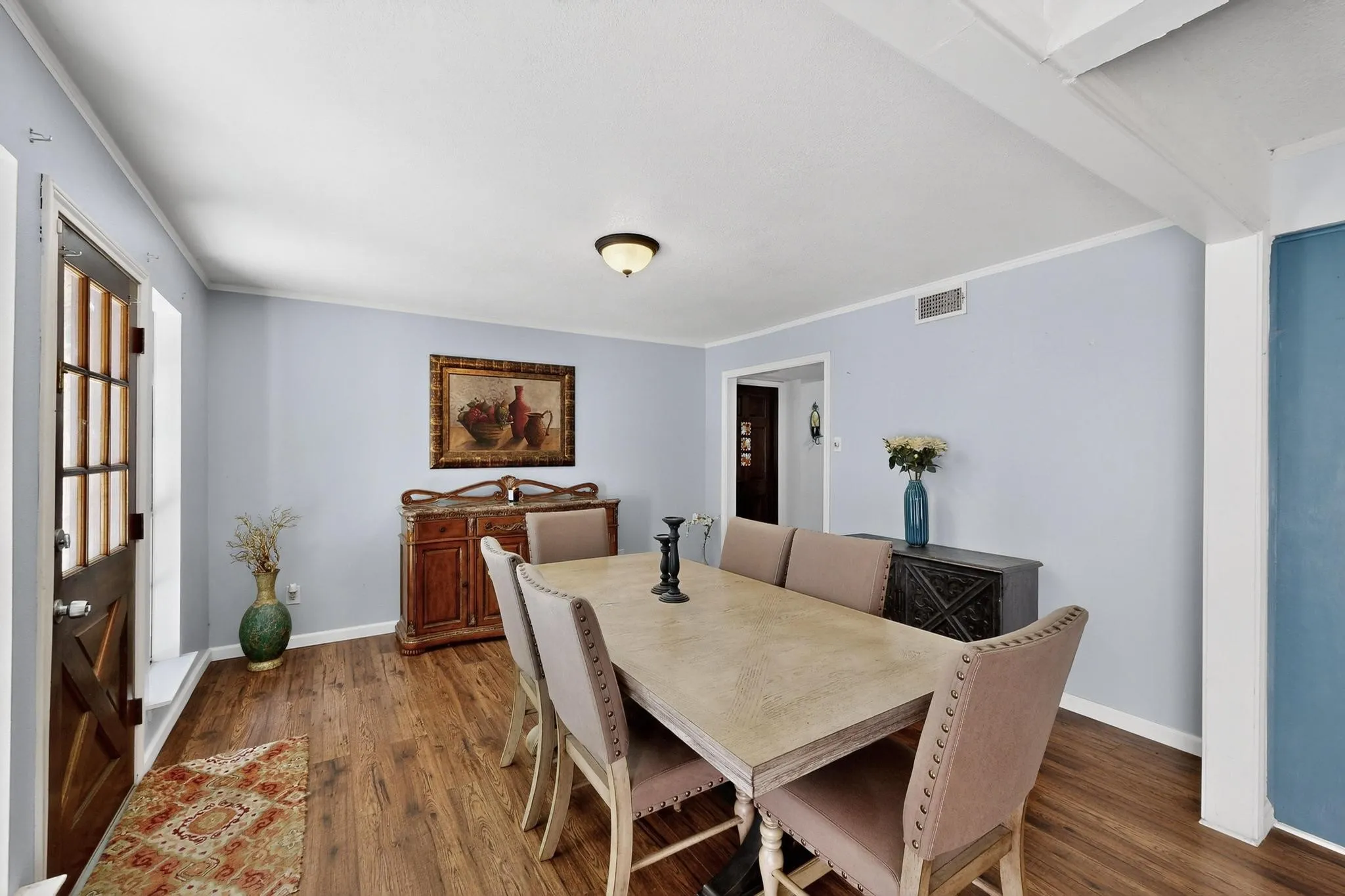Dining area with dark wood-type flooring and ornamental molding