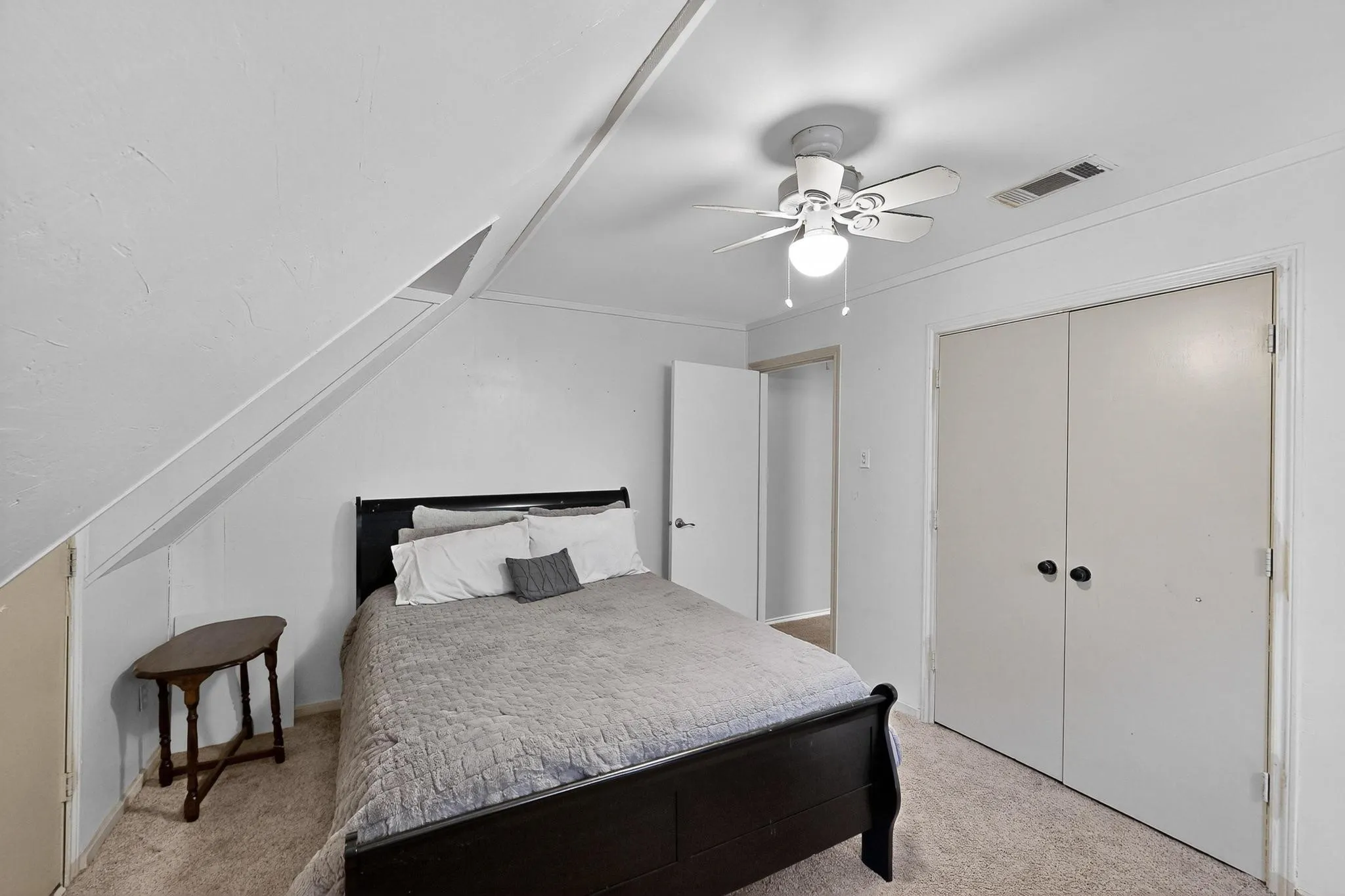 Bedroom featuring light carpet, ceiling fan, a closet, and vaulted ceiling