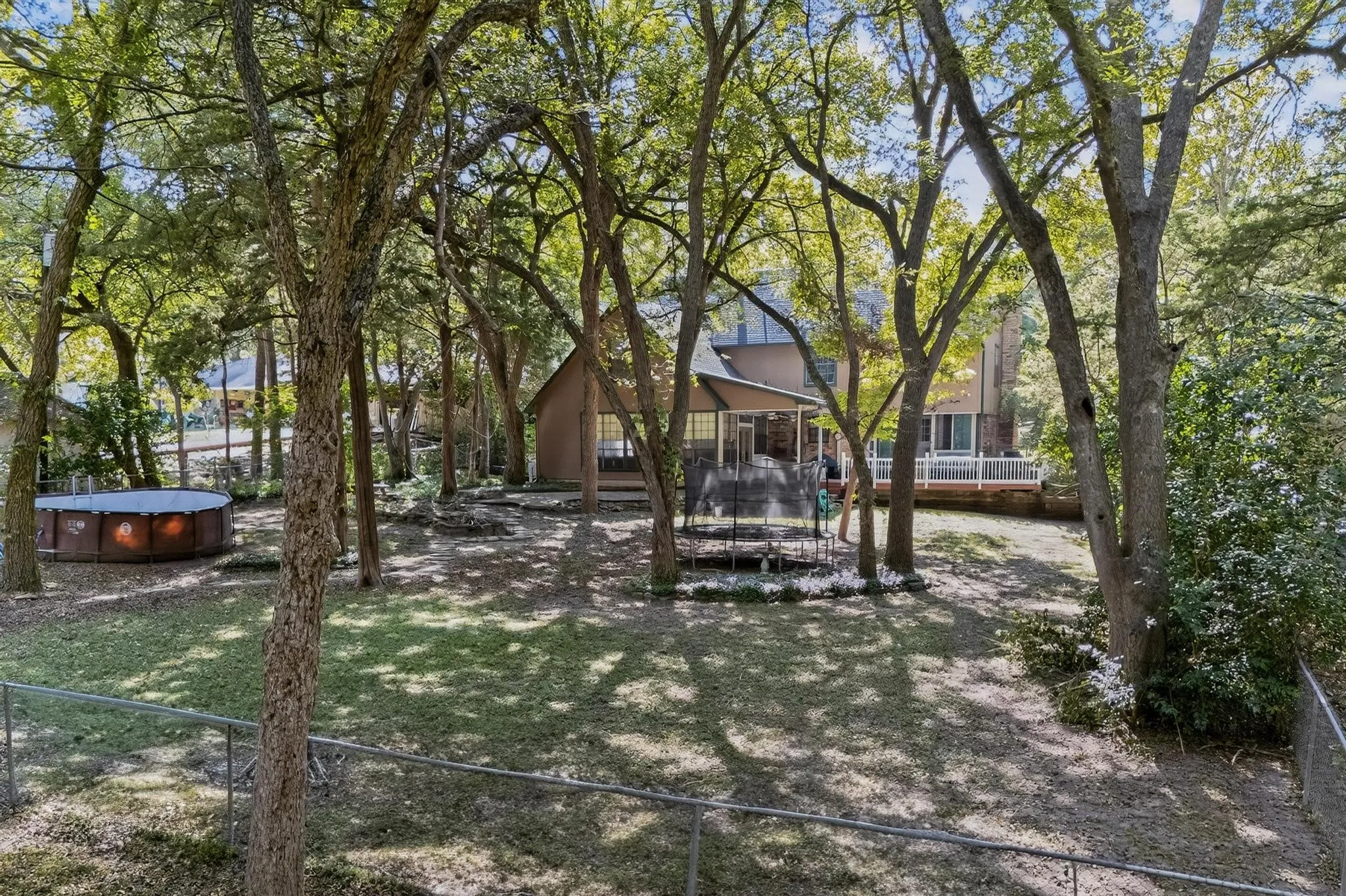 View of yard with a trampoline and a wooden deck