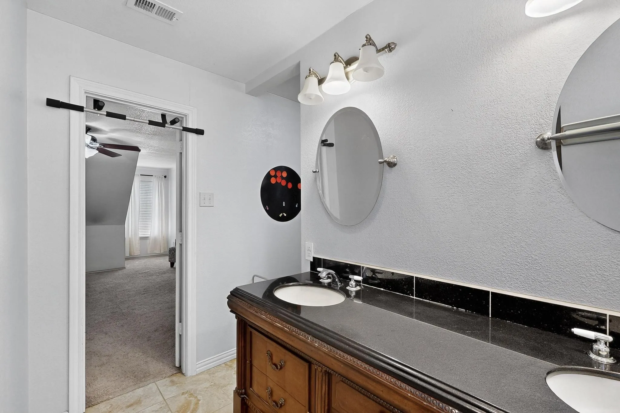 Bathroom with double vanity and light tile patterned floors