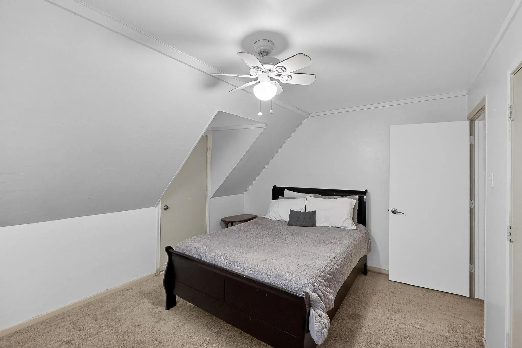 Bedroom with ornamental molding, light colored carpet, a ceiling fan, and lofted ceiling