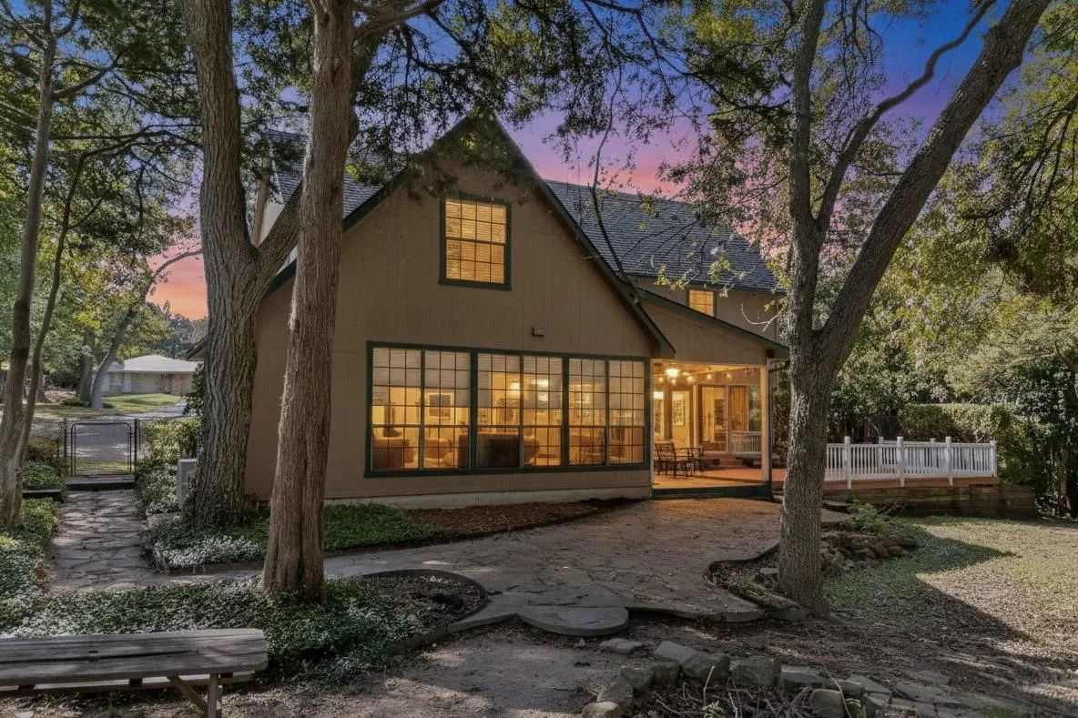 Back of property at dusk with a deck and a gate