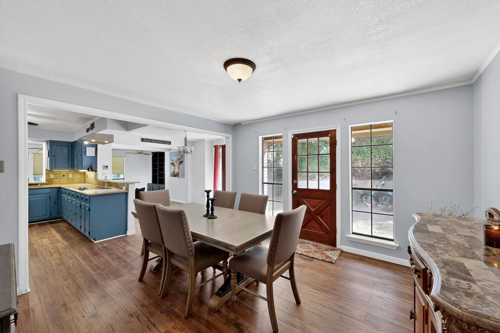 Dining space featuring dark wood-style flooring, a textured ceiling, and a chandelier