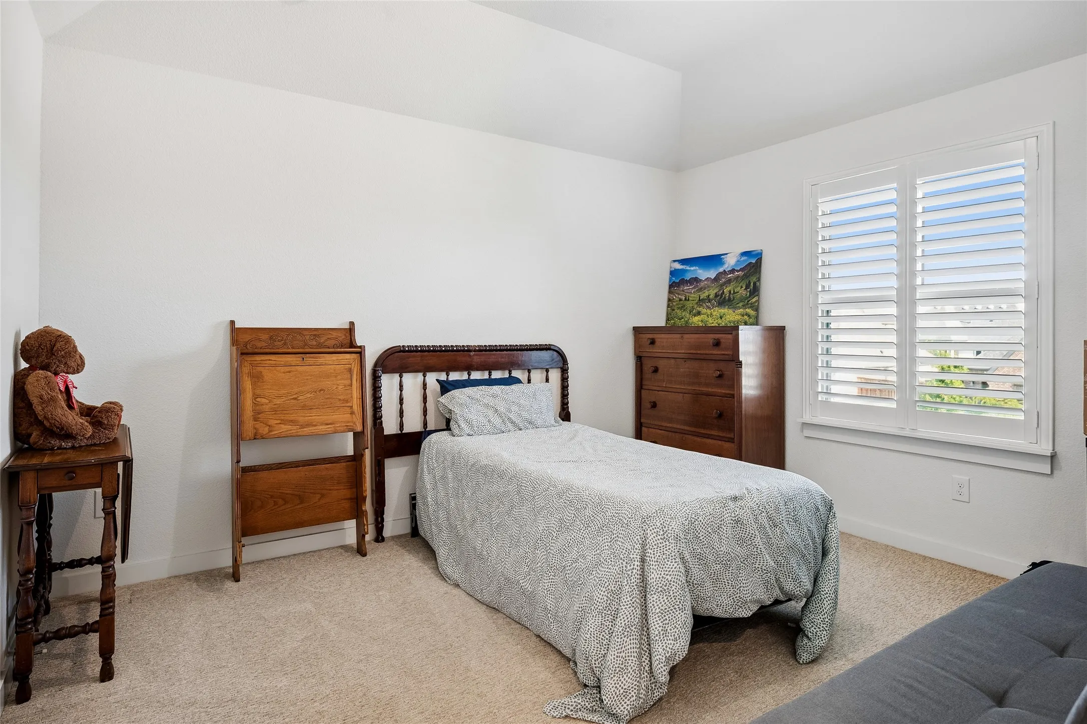 Upstairs secondary bedroom with shutters overlooking the front yard