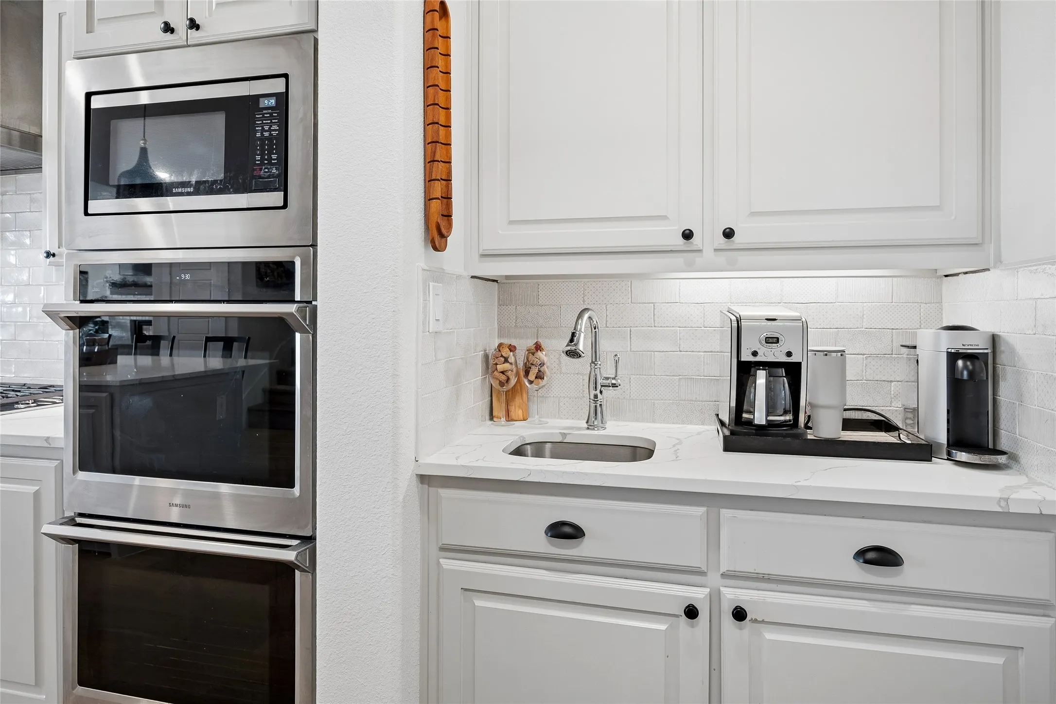 The double ovens and microwave are close to the second sink.