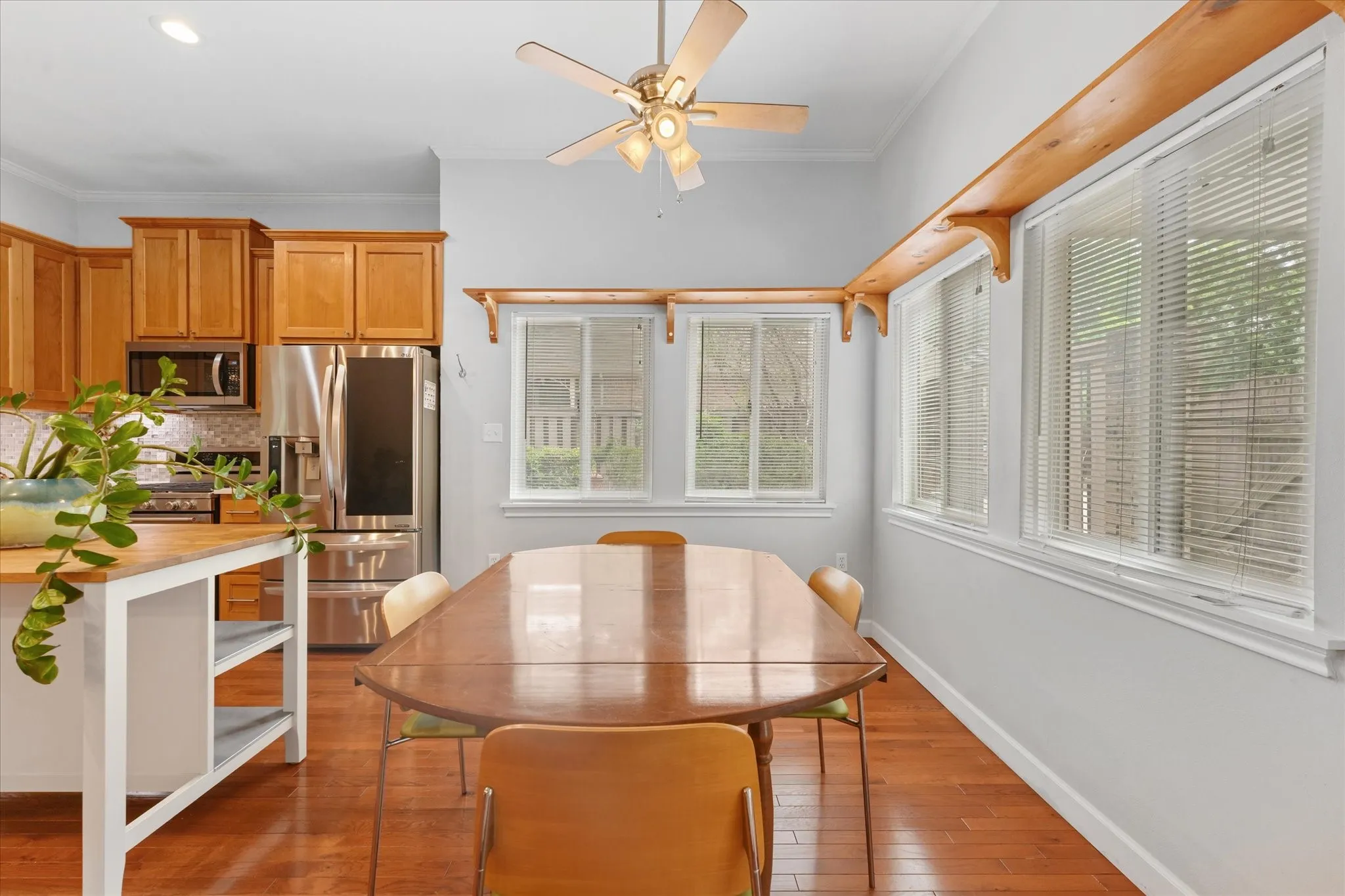 Breakfast area with surrounding windows, natural light, hardwood flooring, and space for everyday dining overlooking the private courtyard area.