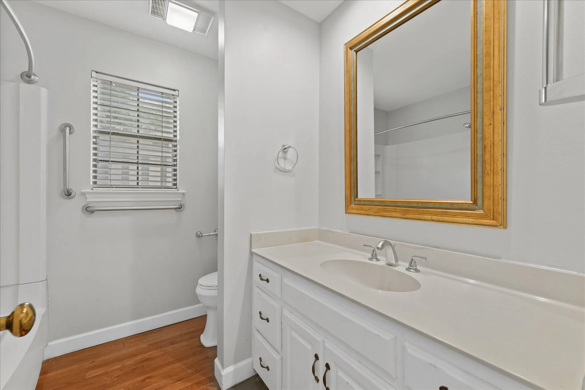 Full downstairs bathroom with updated paint, large vanity, and tub-shower combination conveniently located near the flex room and main living areas.