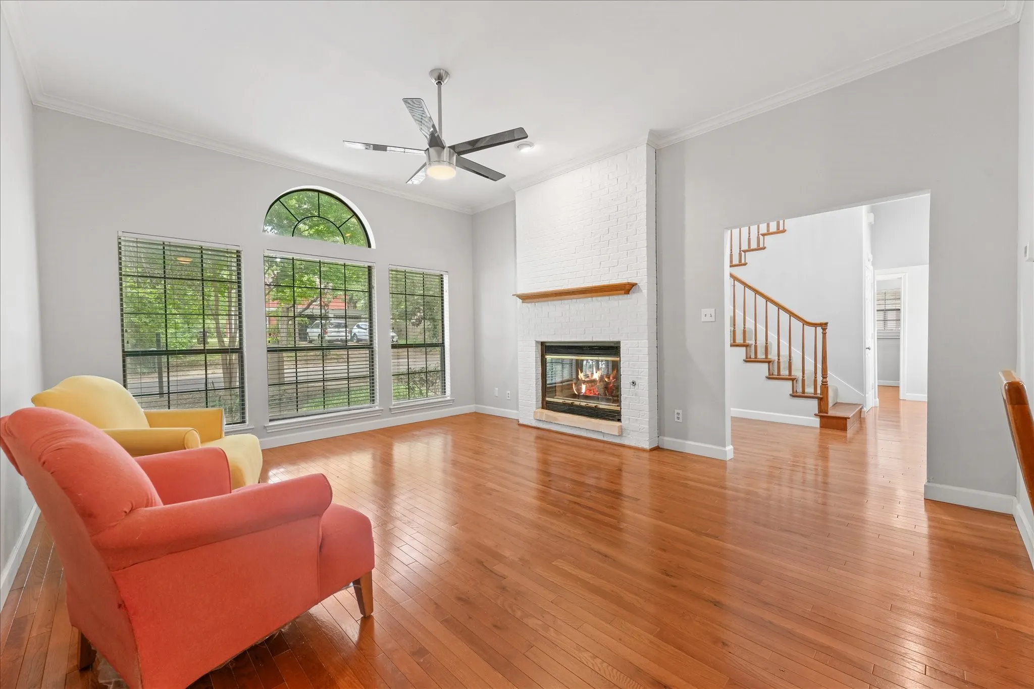 Open living area with hardwood floors, modern paint colors, gas fireplace, and seamless connection to the dining room and kitchen for entertaining.