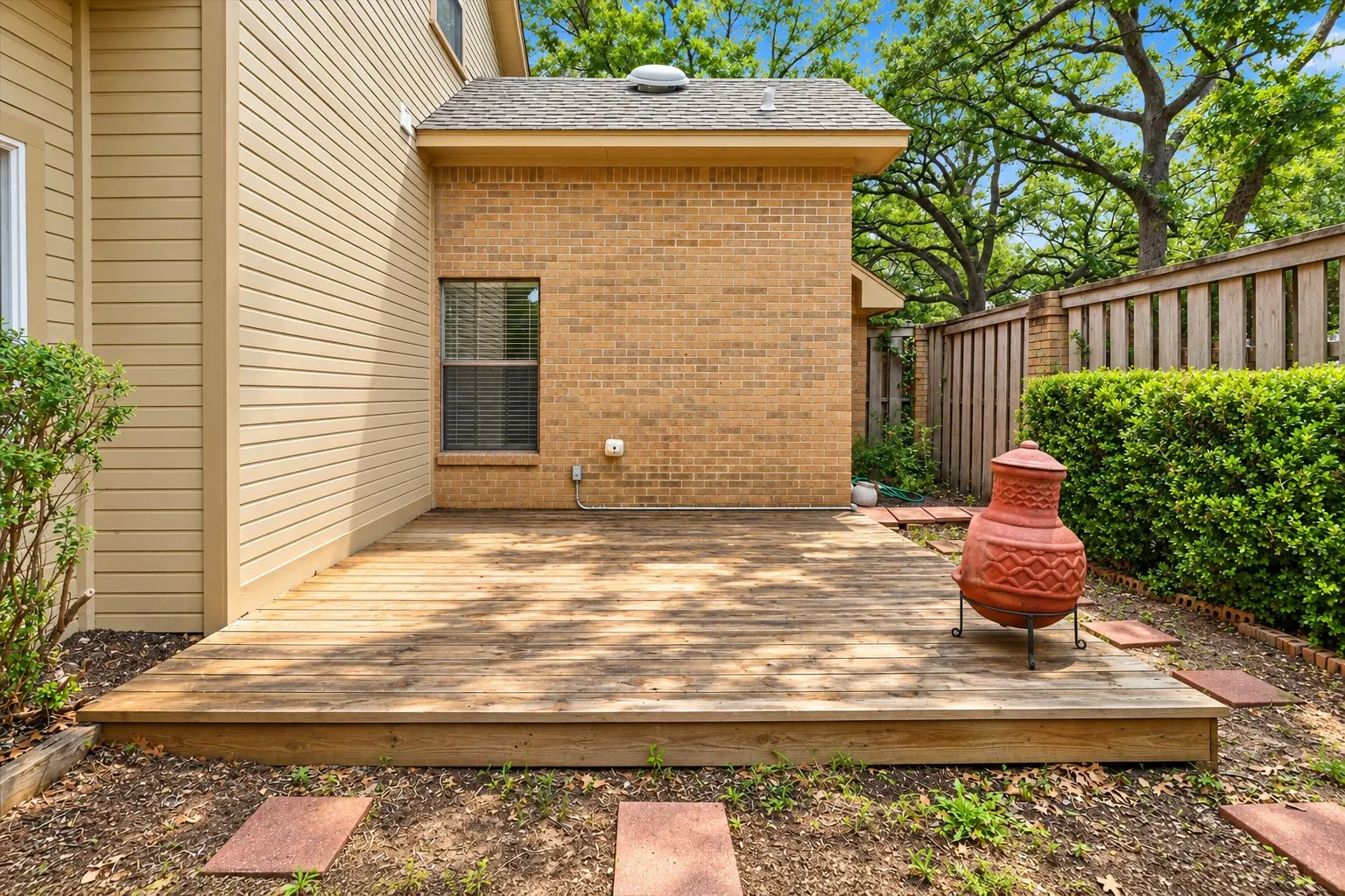 Private backyard deck with mature trees, fenced yard, and space for outdoor dining, grilling, or entertaining.