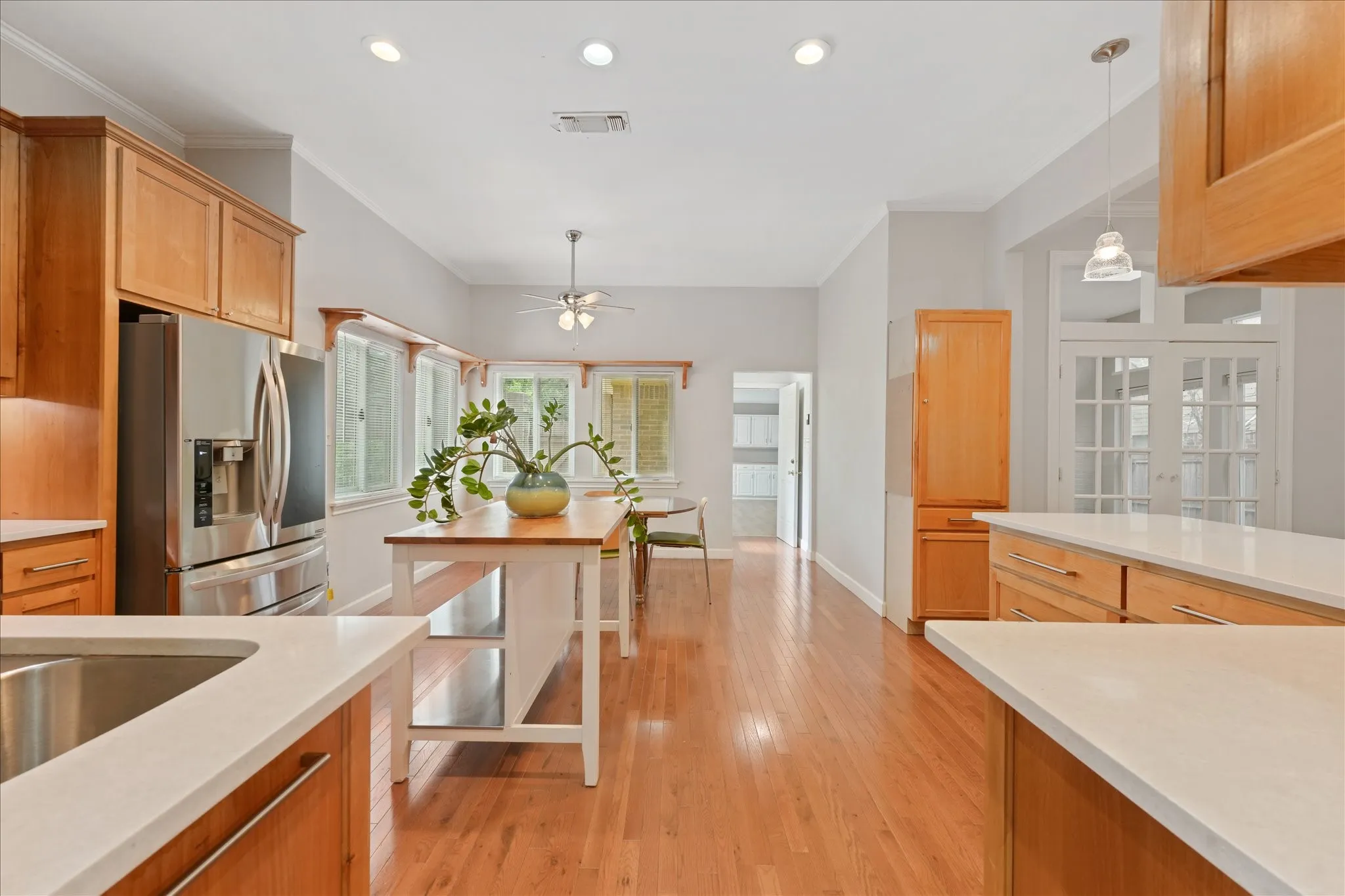 Large kitchen with extensive cabinet storage, recessed lighting, stainless steel appliances, and open flow into the breakfast and living areas.