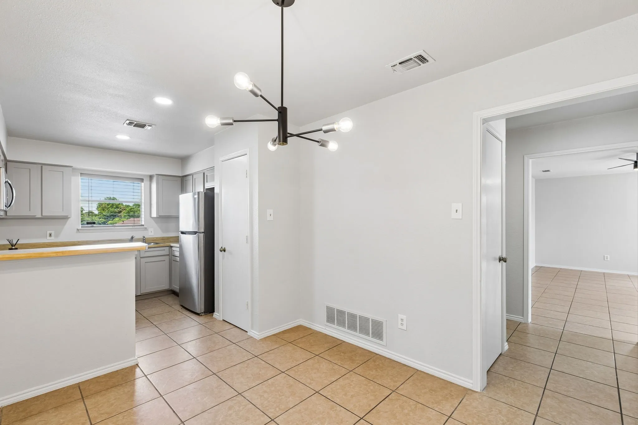 Kitchen featuring light gray cabinetry, stainless steel appliances, and a wood-finish breakfast bar