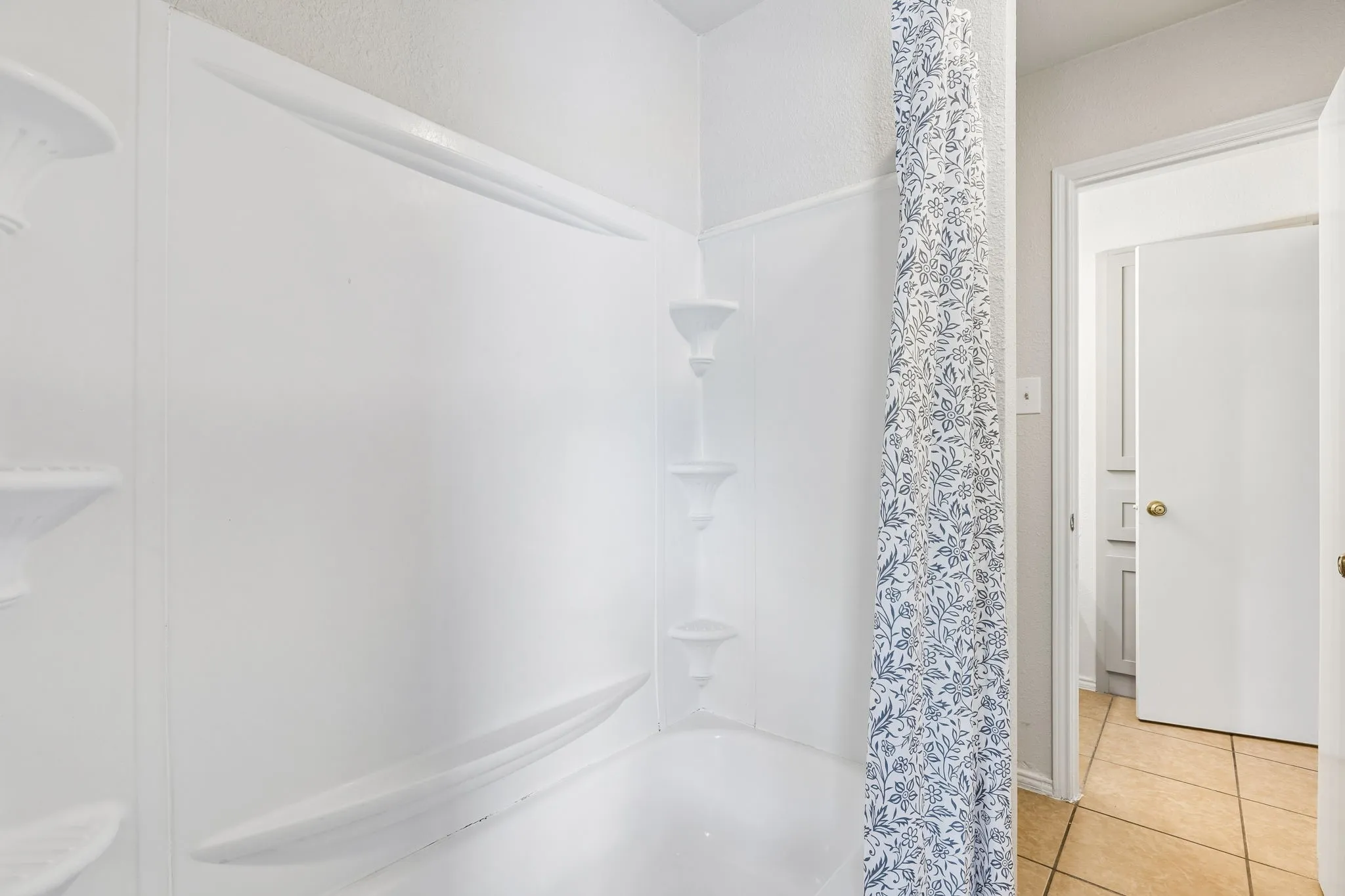 White tub/shower combination with integrated shelving