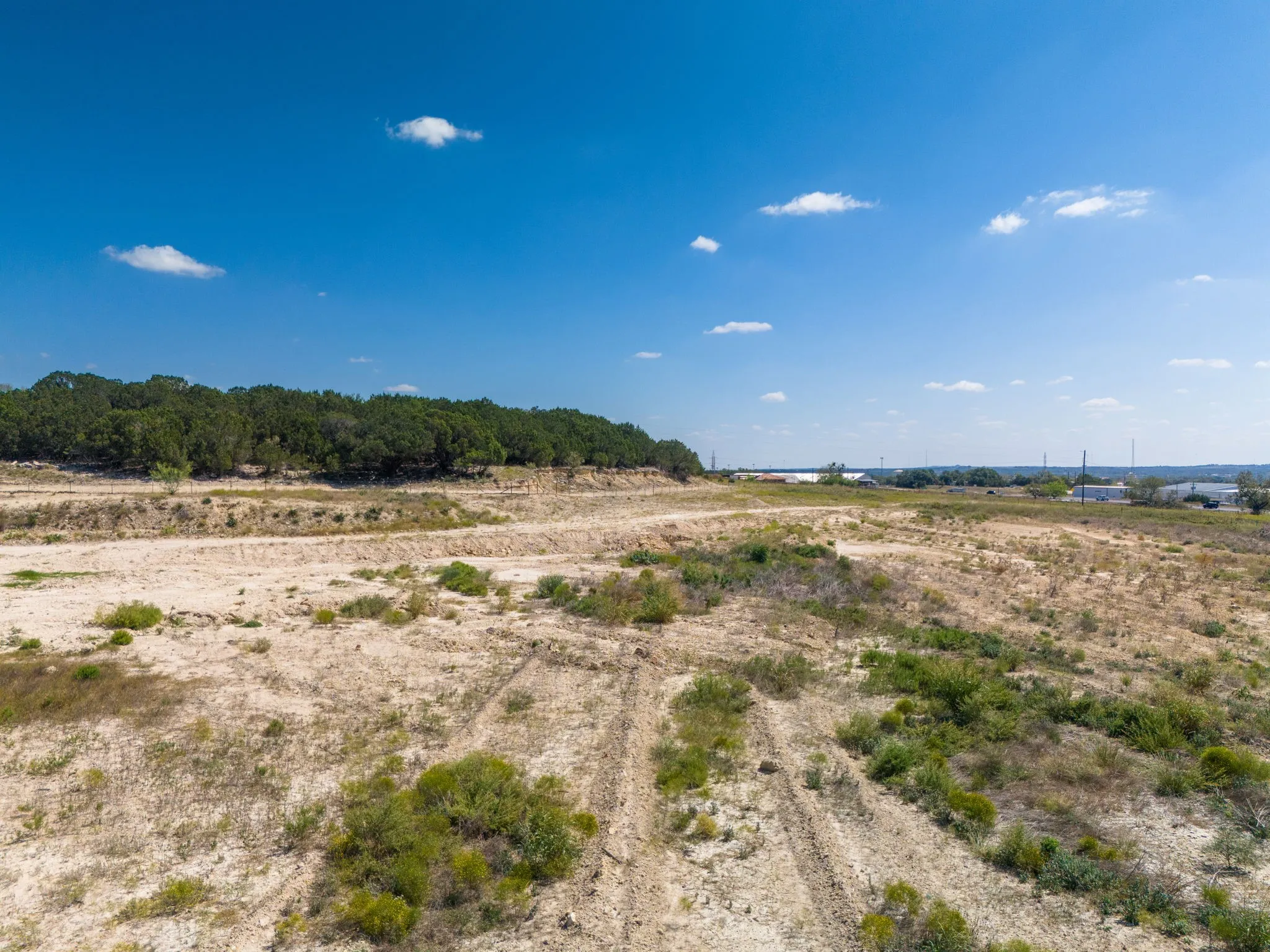 Expansive land parcel featuring natural terrain and distant structures