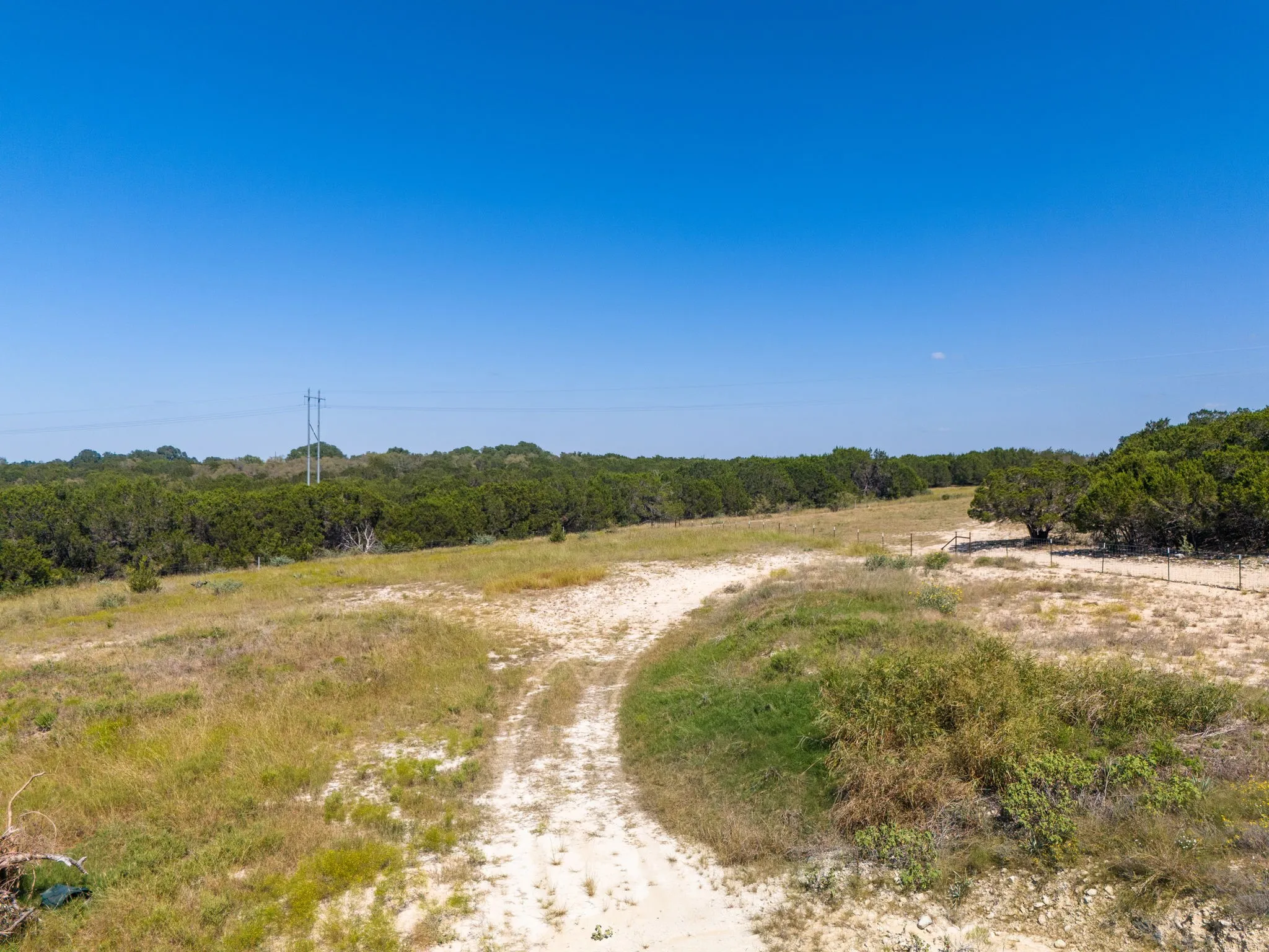Expansive land parcel featuring natural vegetation and a clear blue sky overhead