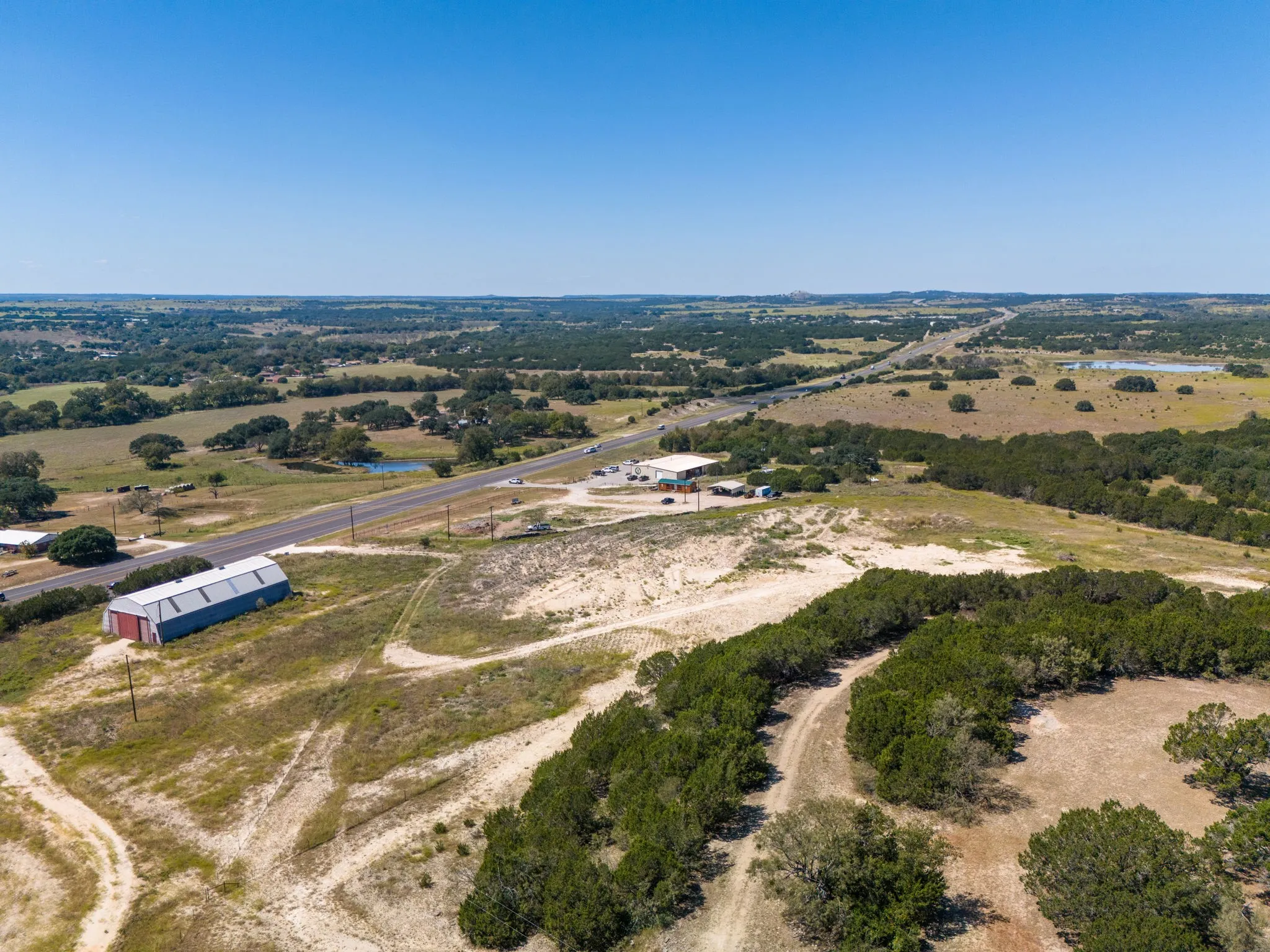 Expansive property featuring a metal-sided barn, direct road frontage, and a substantial land area with abundant trees