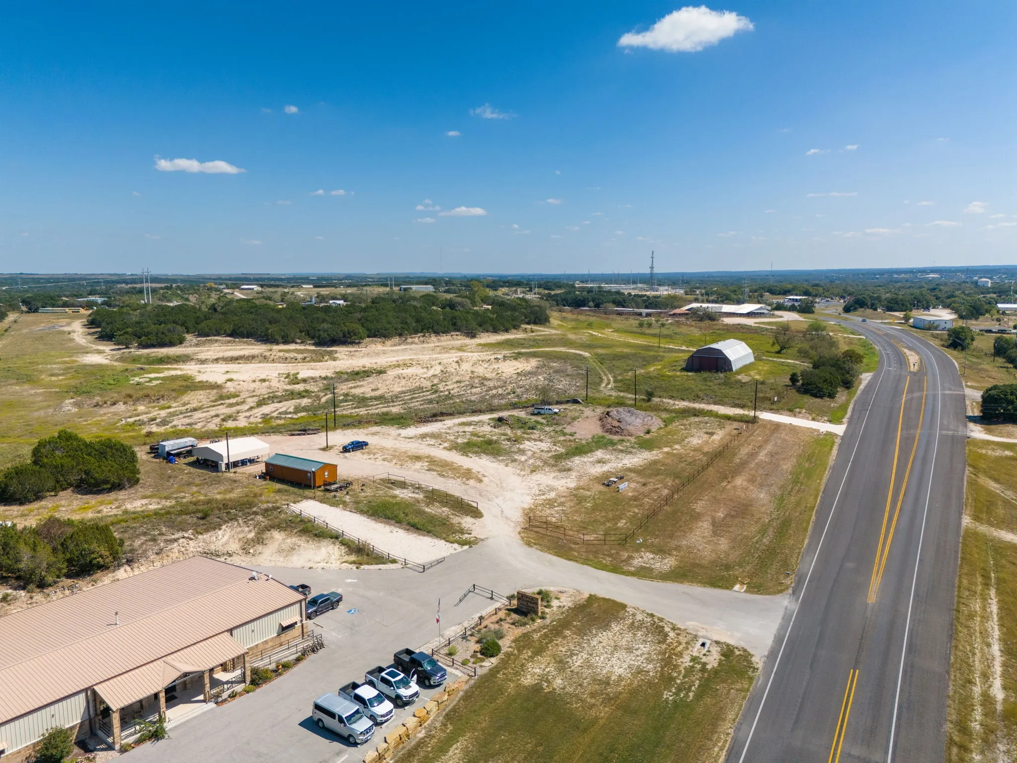 Expansive lot featuring a two-lane asphalt road, gravel access roads, and undeveloped land