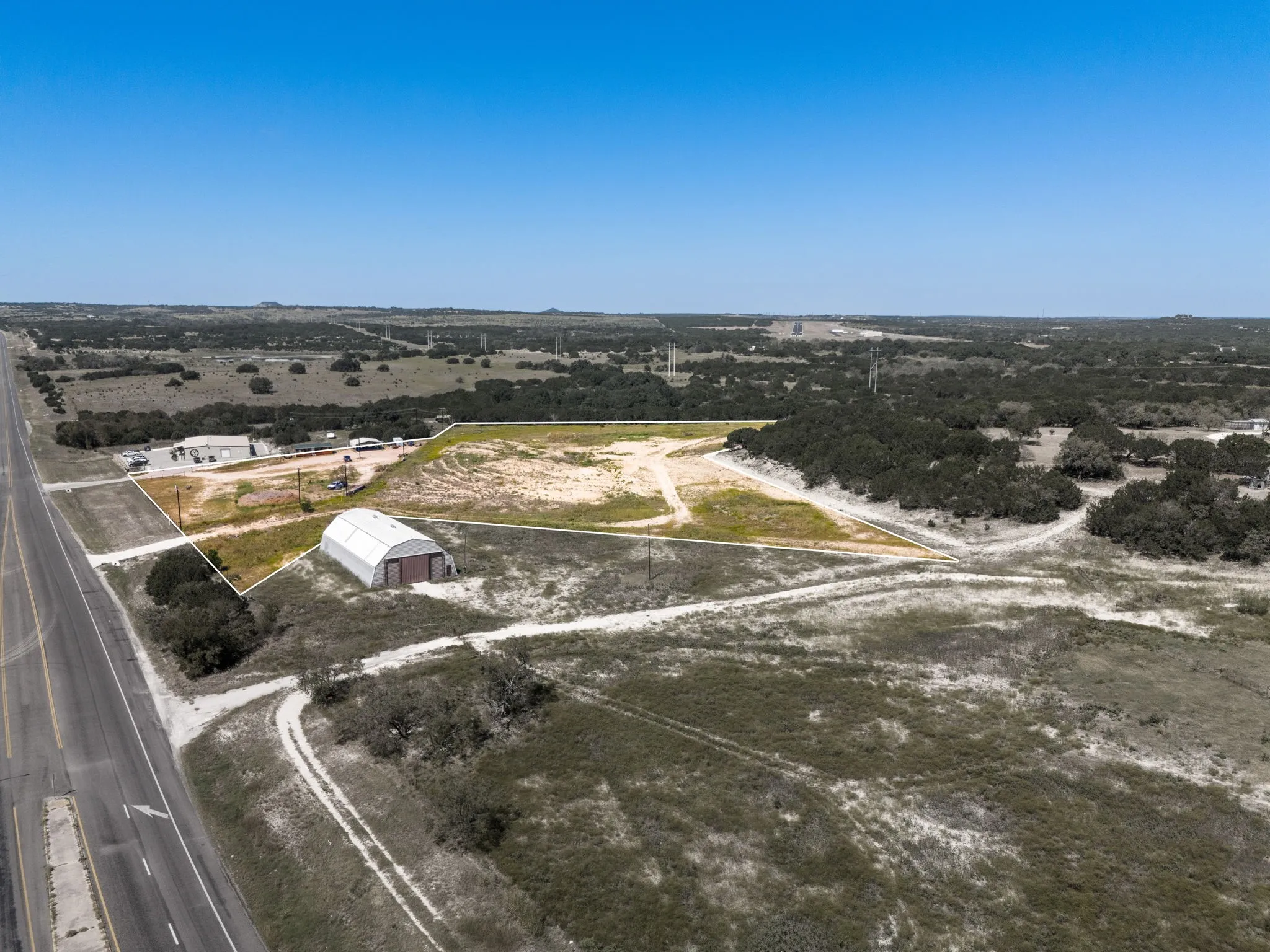 Expansive lot featuring a large quonset hut structure and direct road frontage