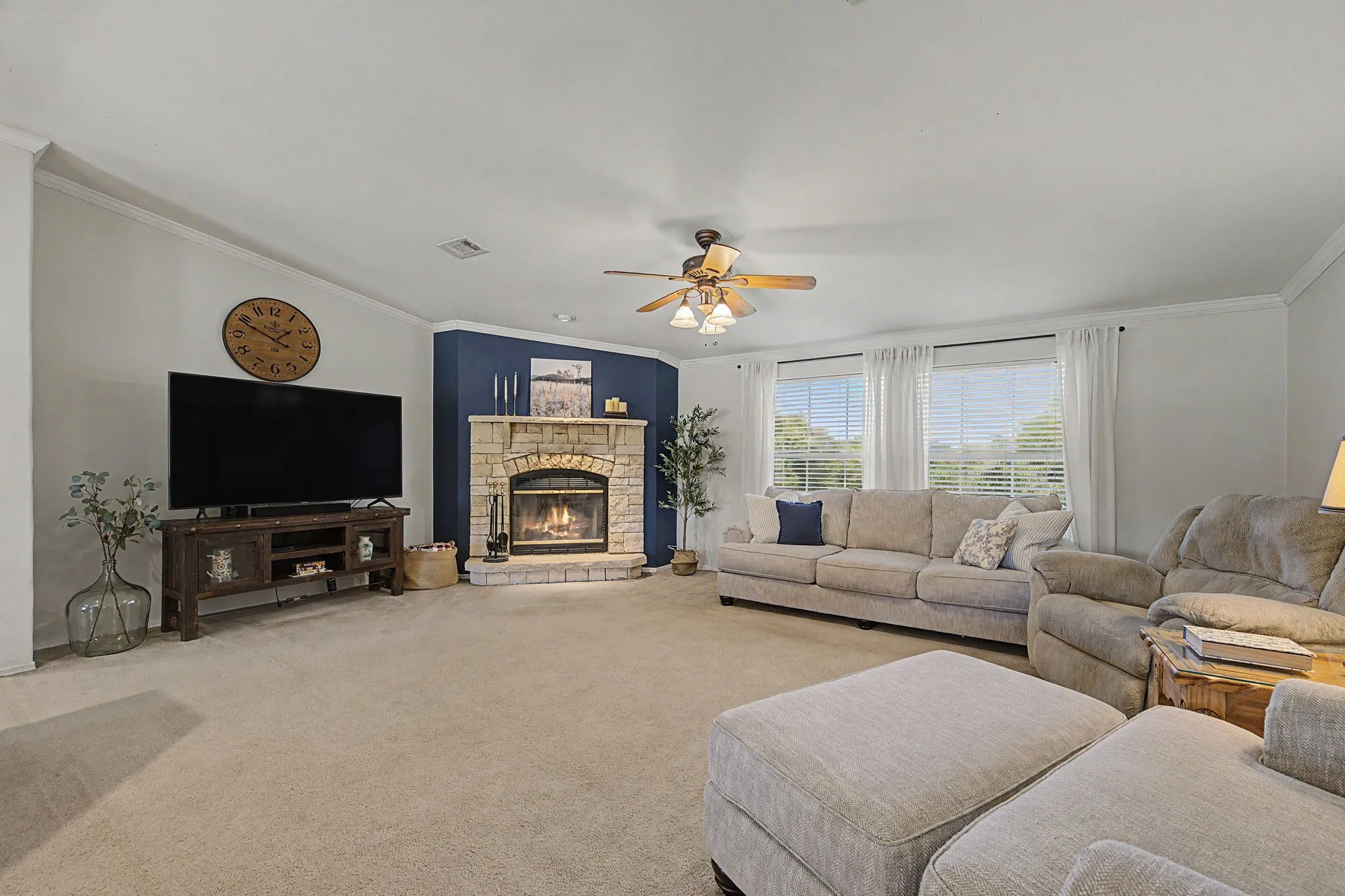 Enormous living room featuring wood burning fireplace and private windows viewing the north side of your property.