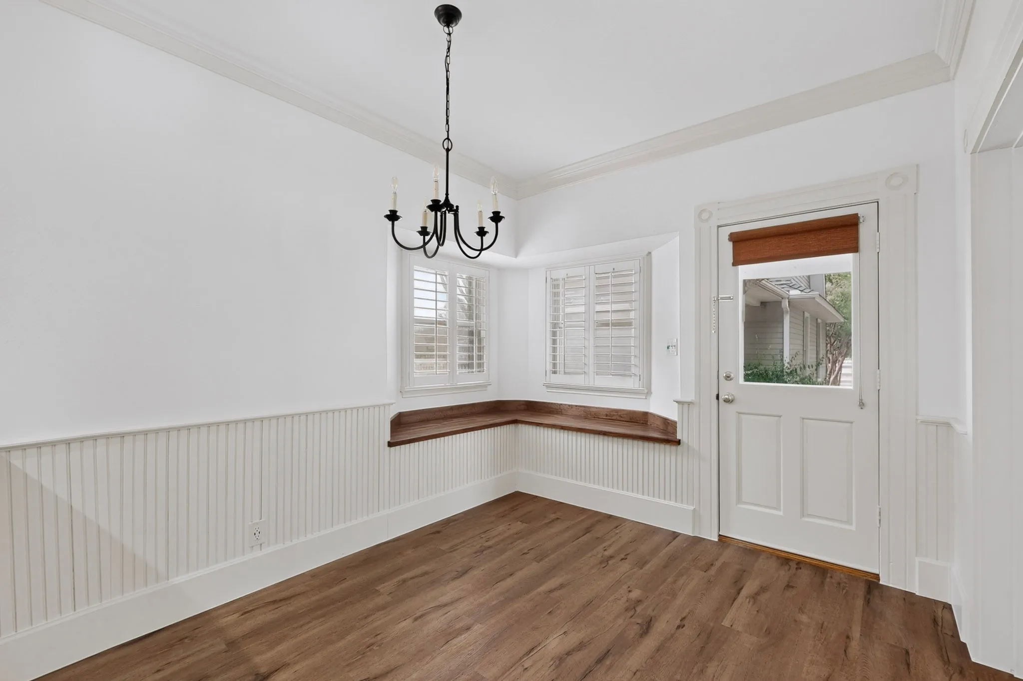 Wood-finish flooring with white beadboard wainscoting