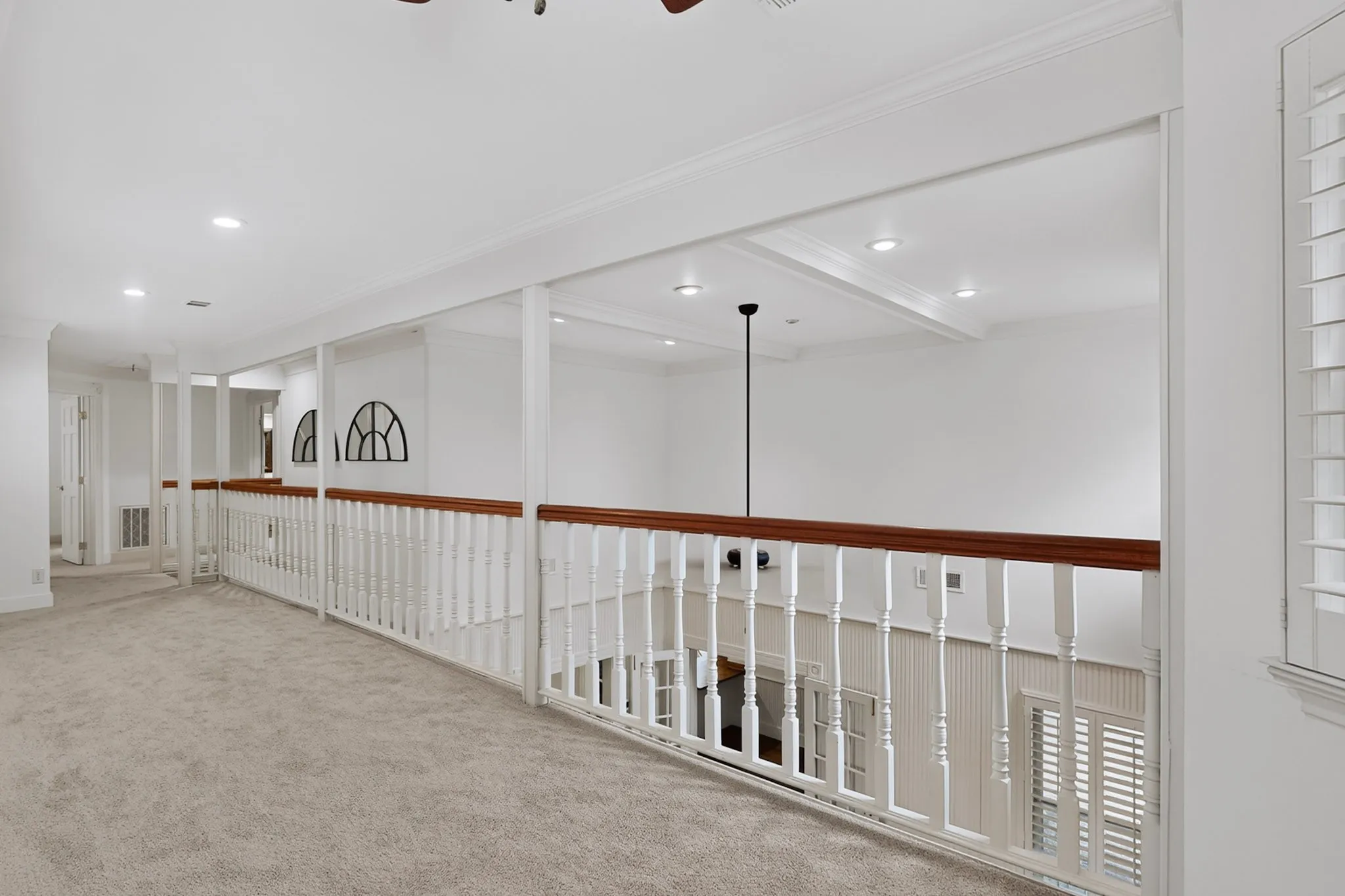 Carpeted hallway with white railing and wood-finish top rail, recessed lighting, and crown molding