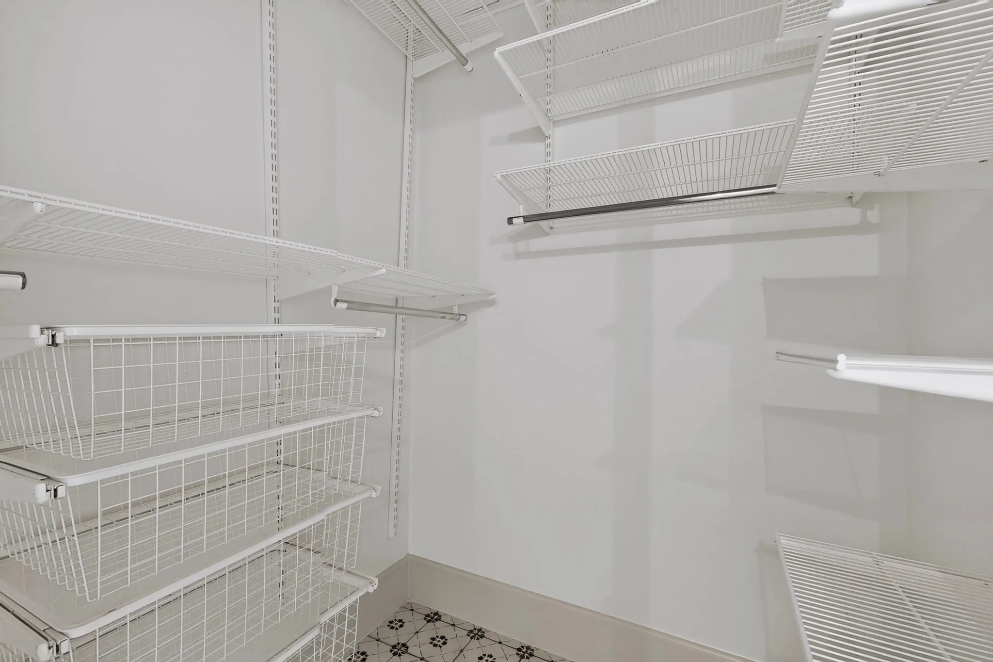 Adjustable wire shelving system with integrated wire baskets, hanging rods, and patterned floor tile
