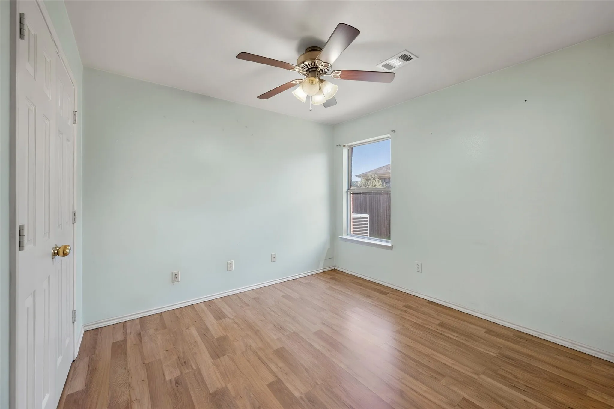 Secondary bedroom with wood look laminate flooring