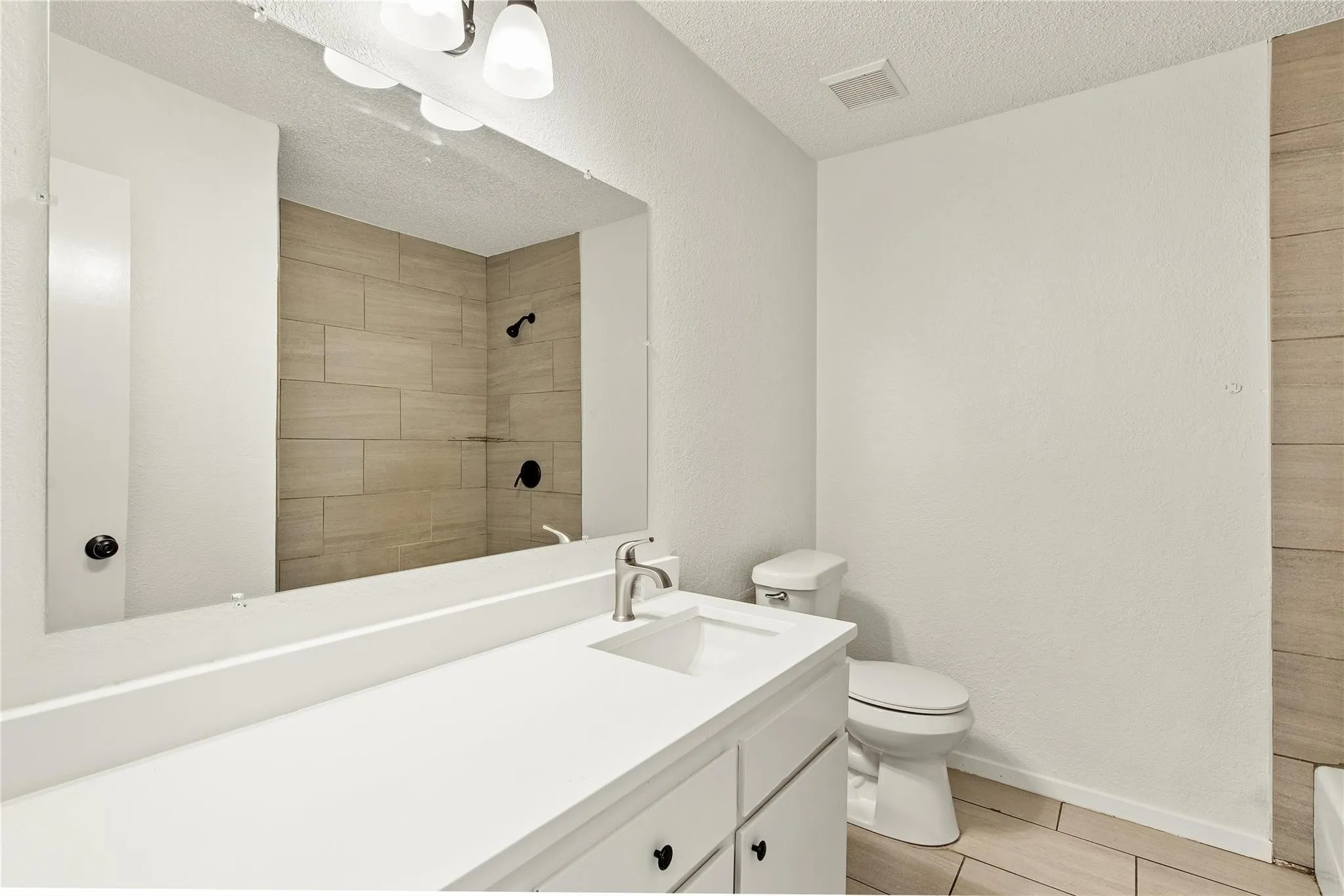 White vanity with an integrated sink and brushed nickel faucet