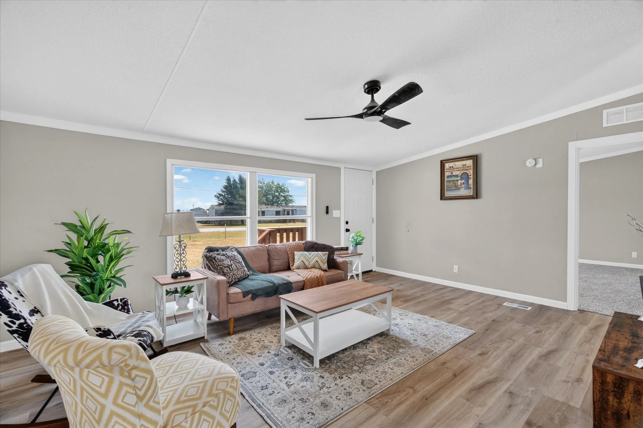 Spacious room with wood-finish flooring, light gray walls, and white trim