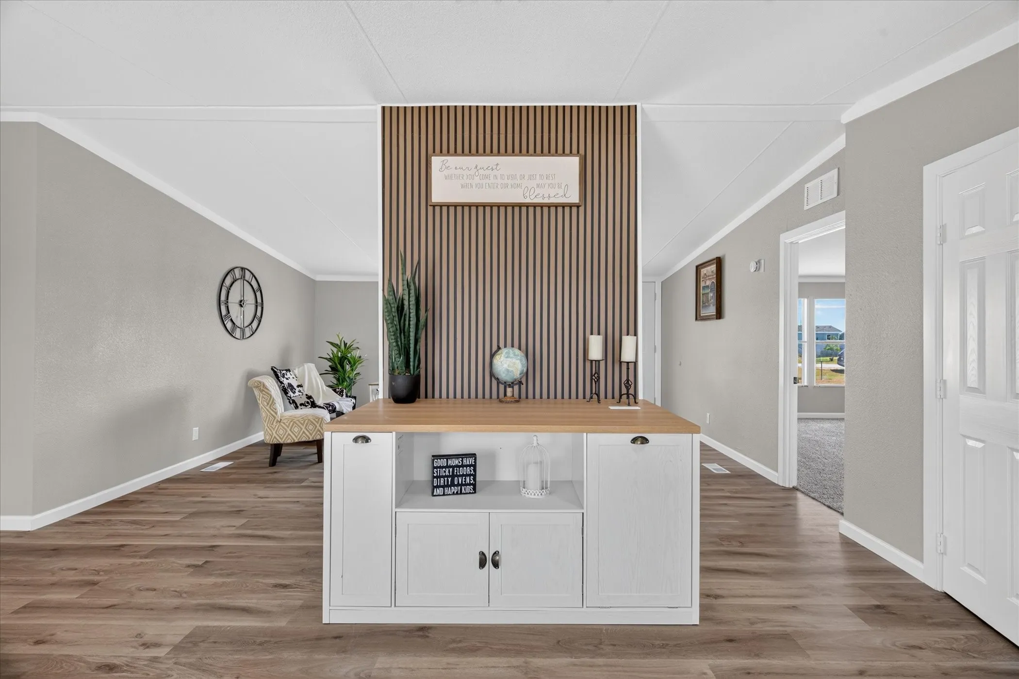 Open concept interior featuring wood-finish flooring, light grey painted walls, and white trim