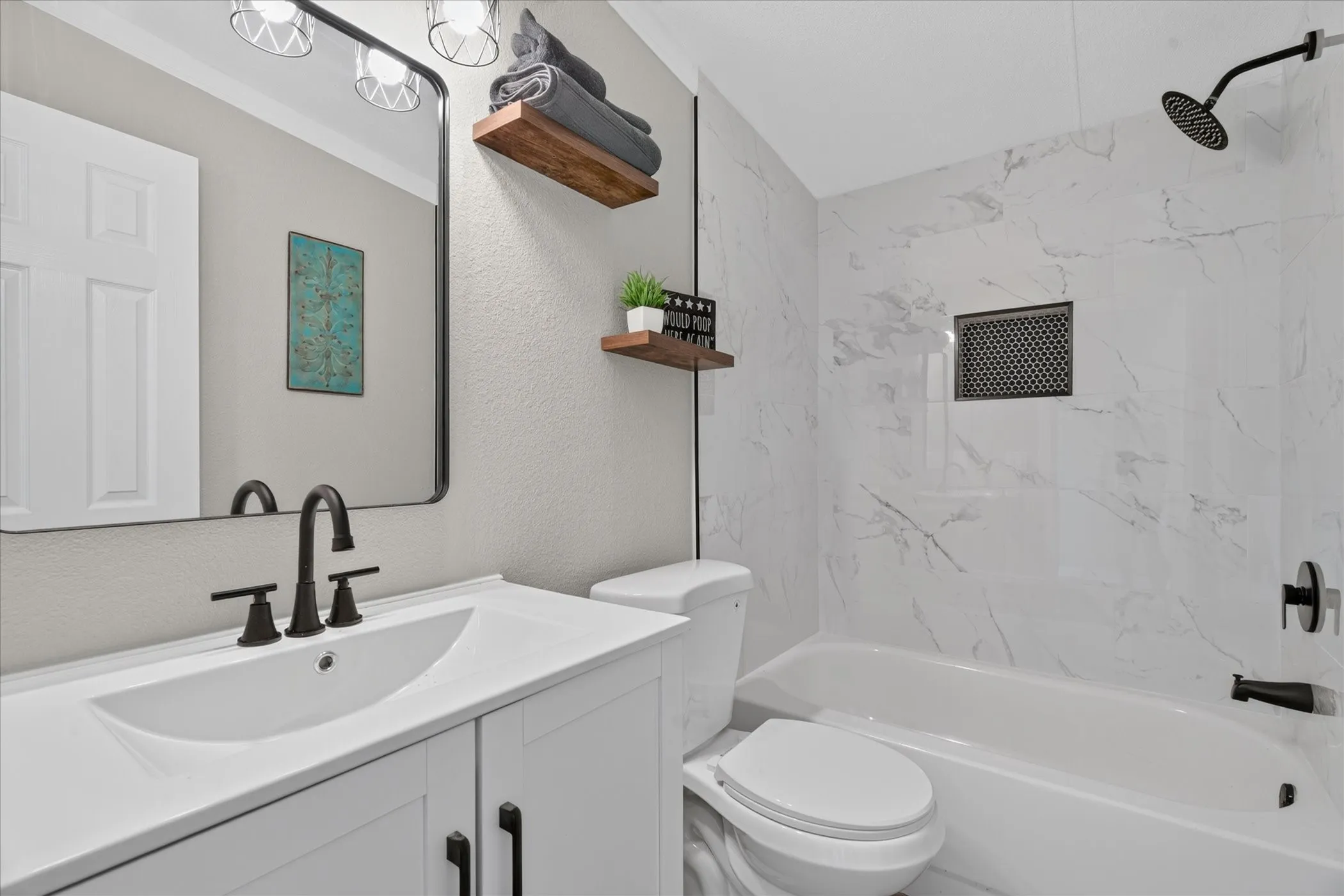 White vanity with integrated sink and matte black faucet
