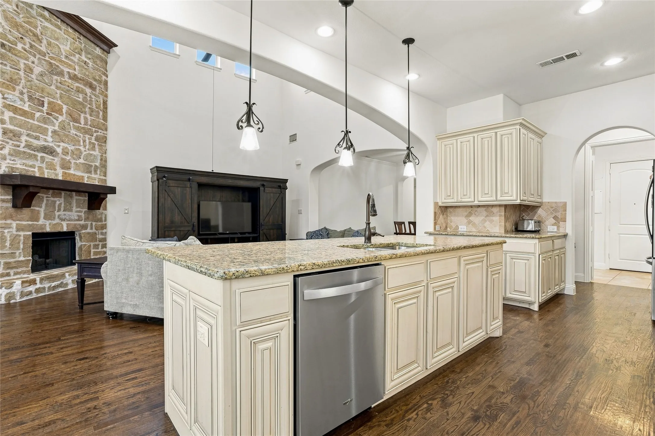 Gourmet kitchen with a center island, granite countertops, and light-toned cabinetry
