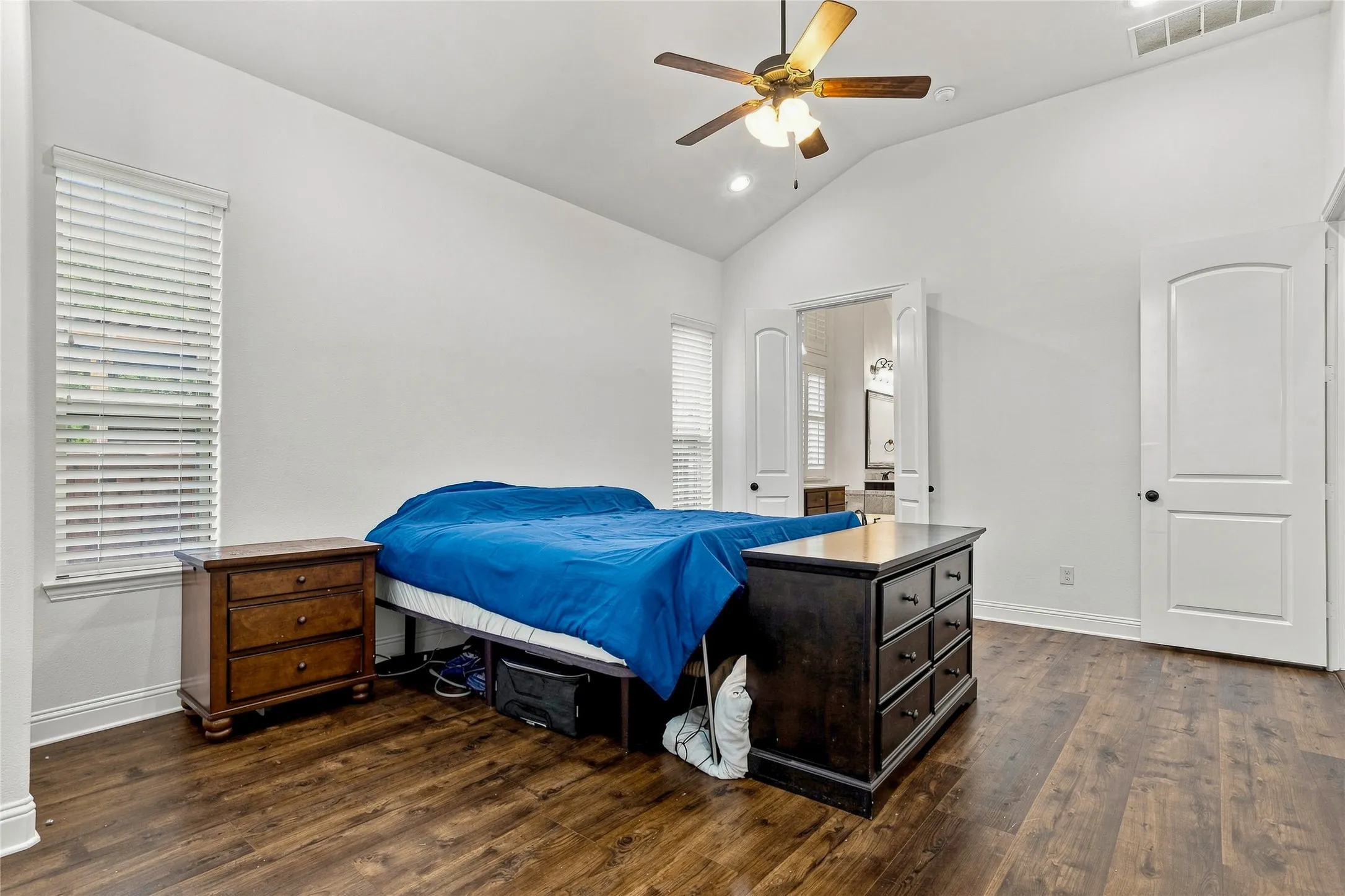 Wood-finish flooring, vaulted ceiling, ceiling fan with integrated lighting, recessed lighting, and arched doorways