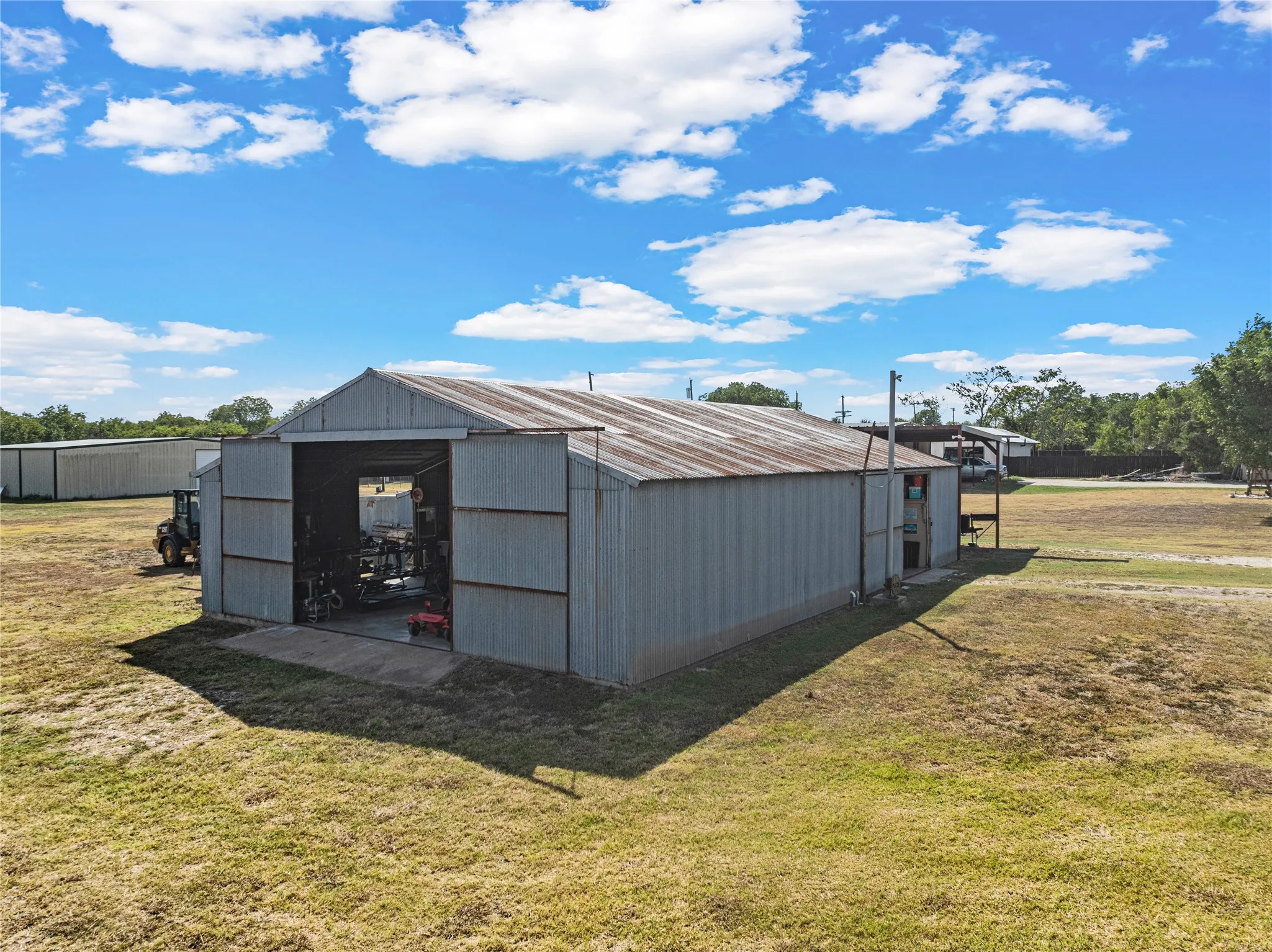 Metal construction barn with a pitched, corrugated roof, and large sliding doors