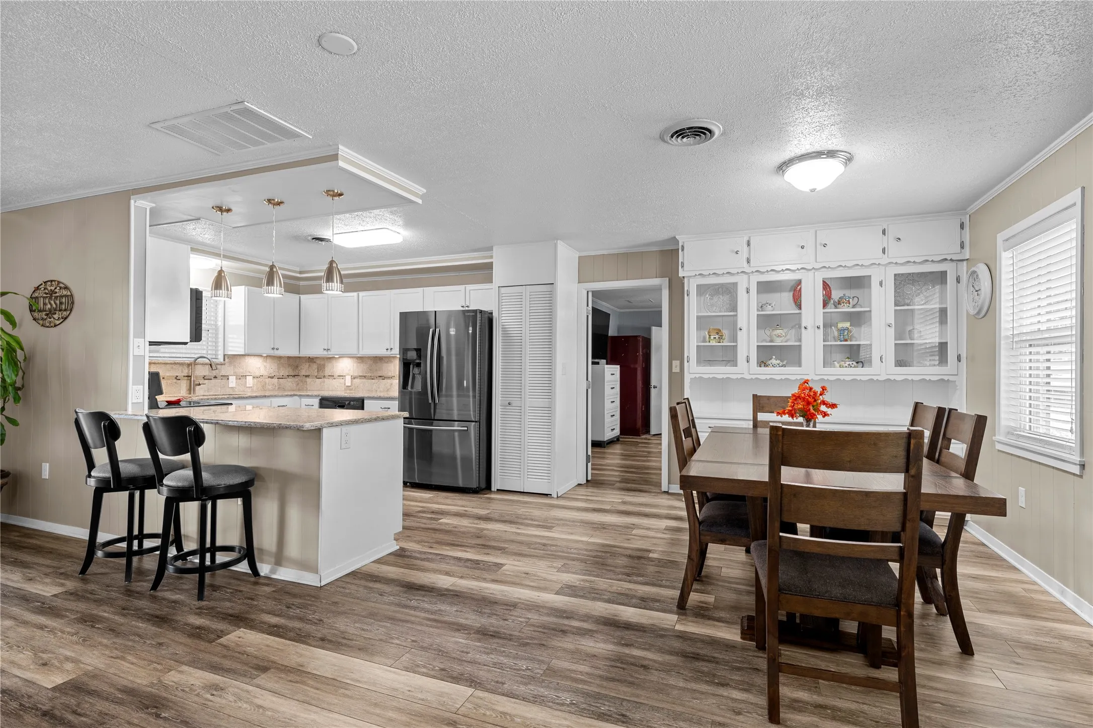 Wood-finish flooring throughout the open-concept kitchen and dining area