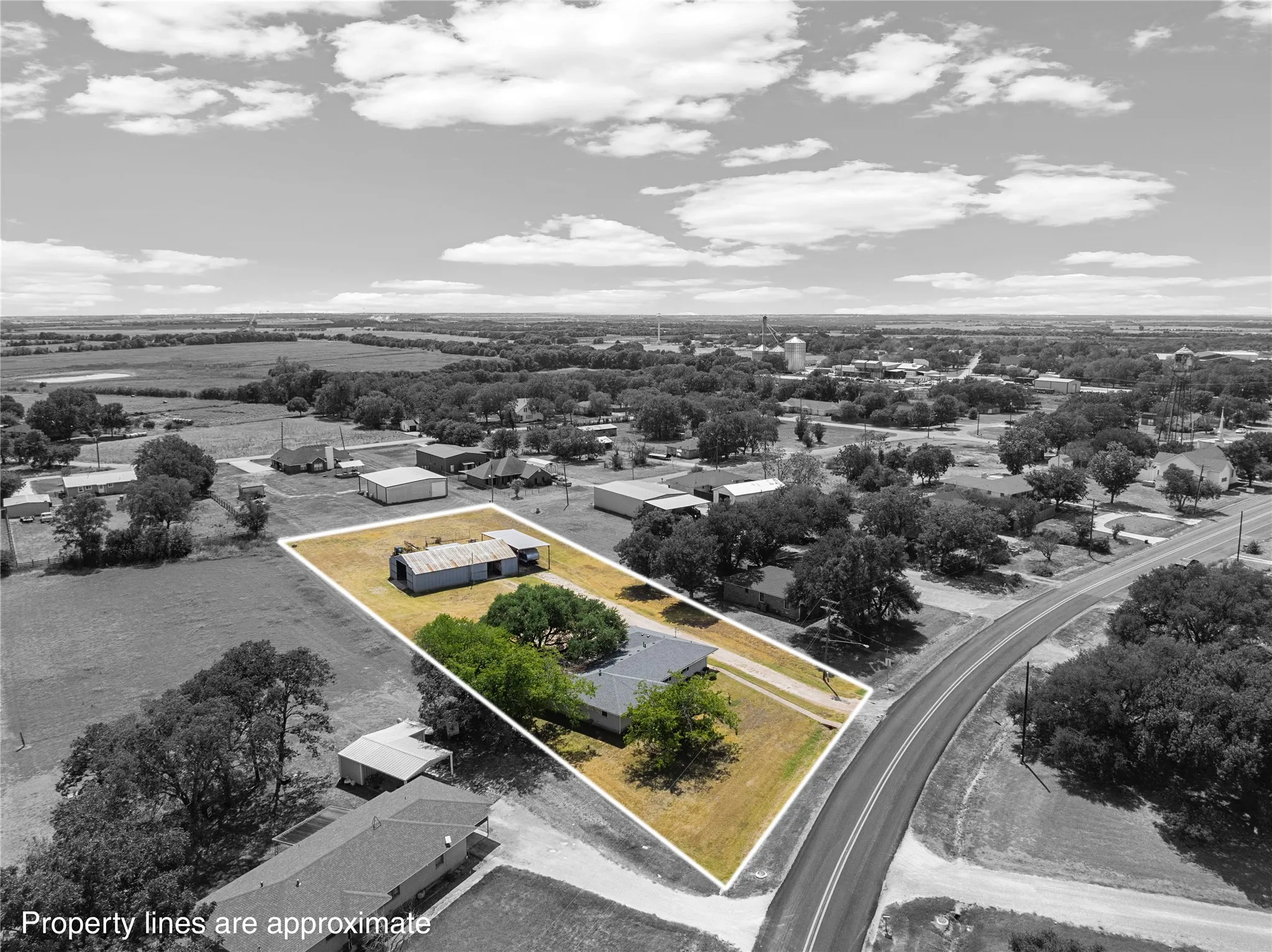 Property featuring a rectangular lot, mature trees, and a paved road frontage