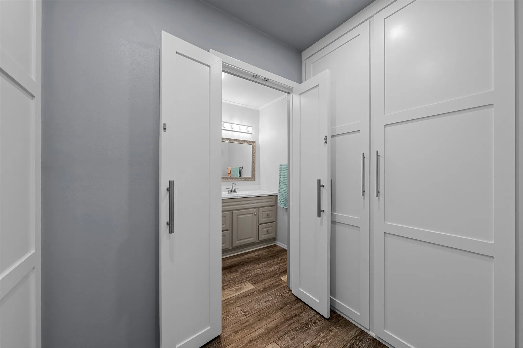 White built-in cabinetry with brushed nickel hardware and wood-finish flooring