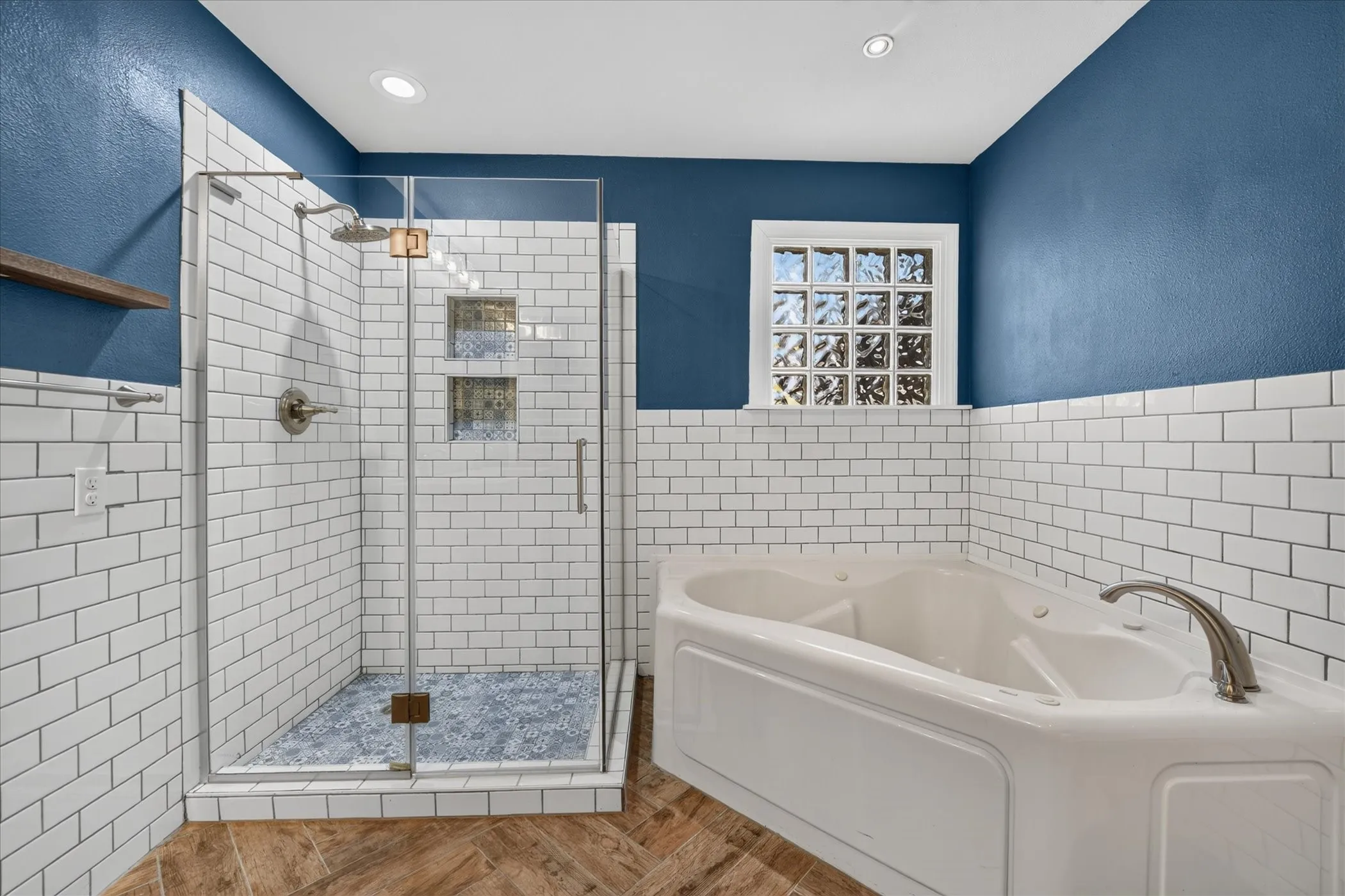 Glass-enclosed shower with subway tile surround, built-in niches, and a textured tile floor