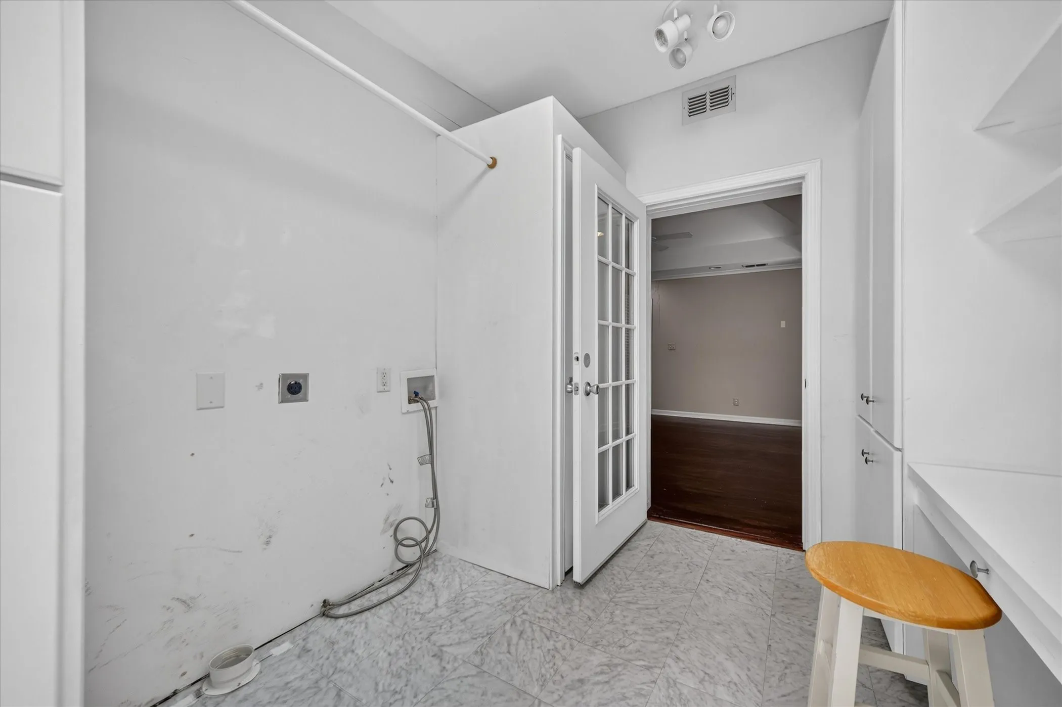 Laundry area with vinyl flooring, built-in cabinetry, and French doors