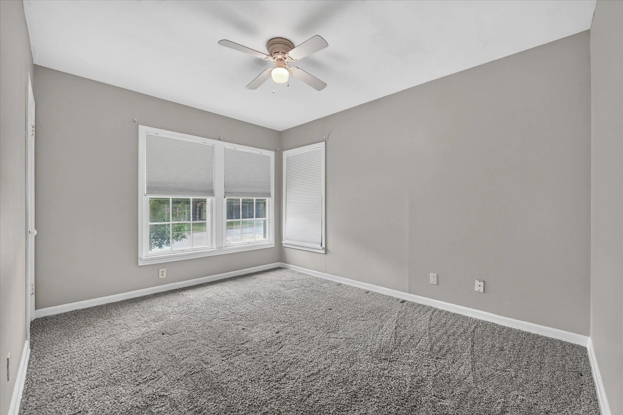 Neutral wall tones with grey carpeting and white trim