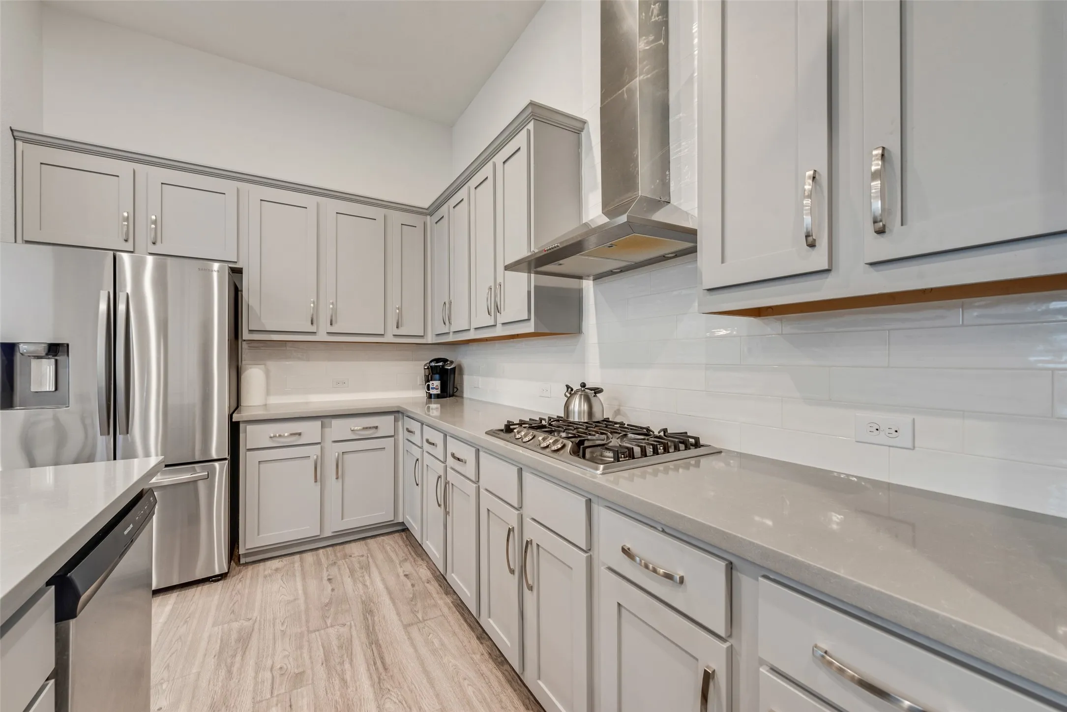Open kitchen with engineered hardwood floors, shaker cabinets, quartz countertops,  and 11 ft ceilings at 1721 Pattenson Trl, Haslet, TX 76052 in Wellington subdivision
