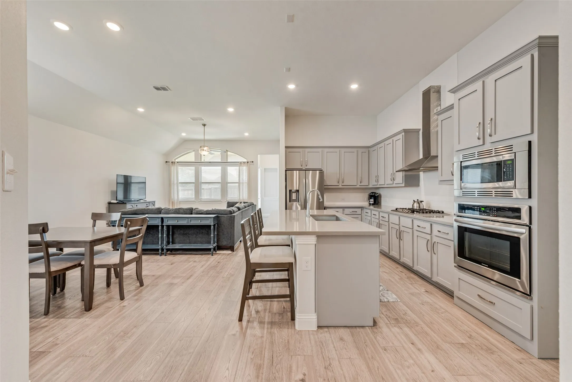 Open kitchen with engineered hardwood floors, shaker cabinets, quartz countertops,  and 11 ft ceilings at 1721 Pattenson Trl, Haslet, TX 76052 in Wellington subdivision